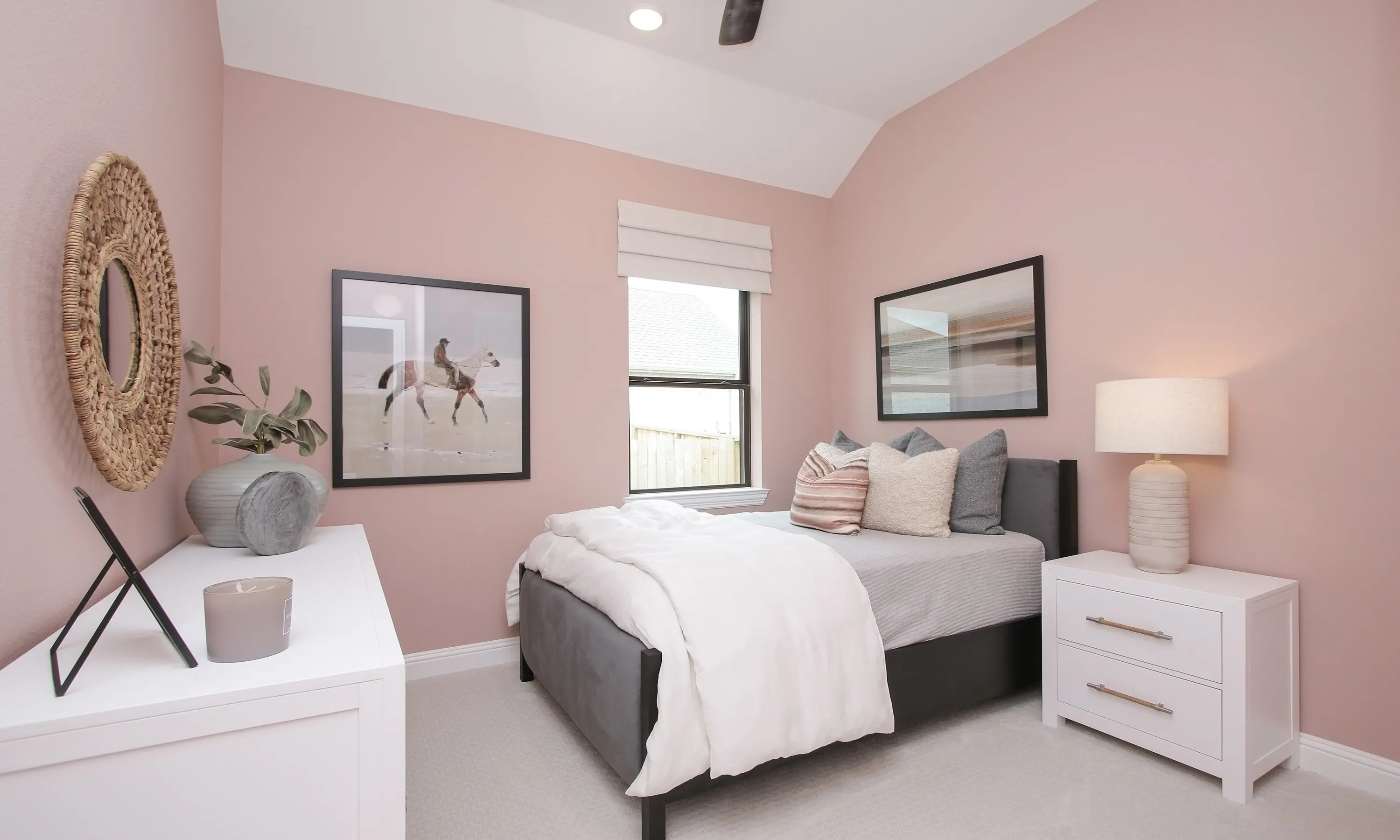 Elegant bedroom with pink walls, cozy bed, large window, and stylish decor in Coastal Point community.