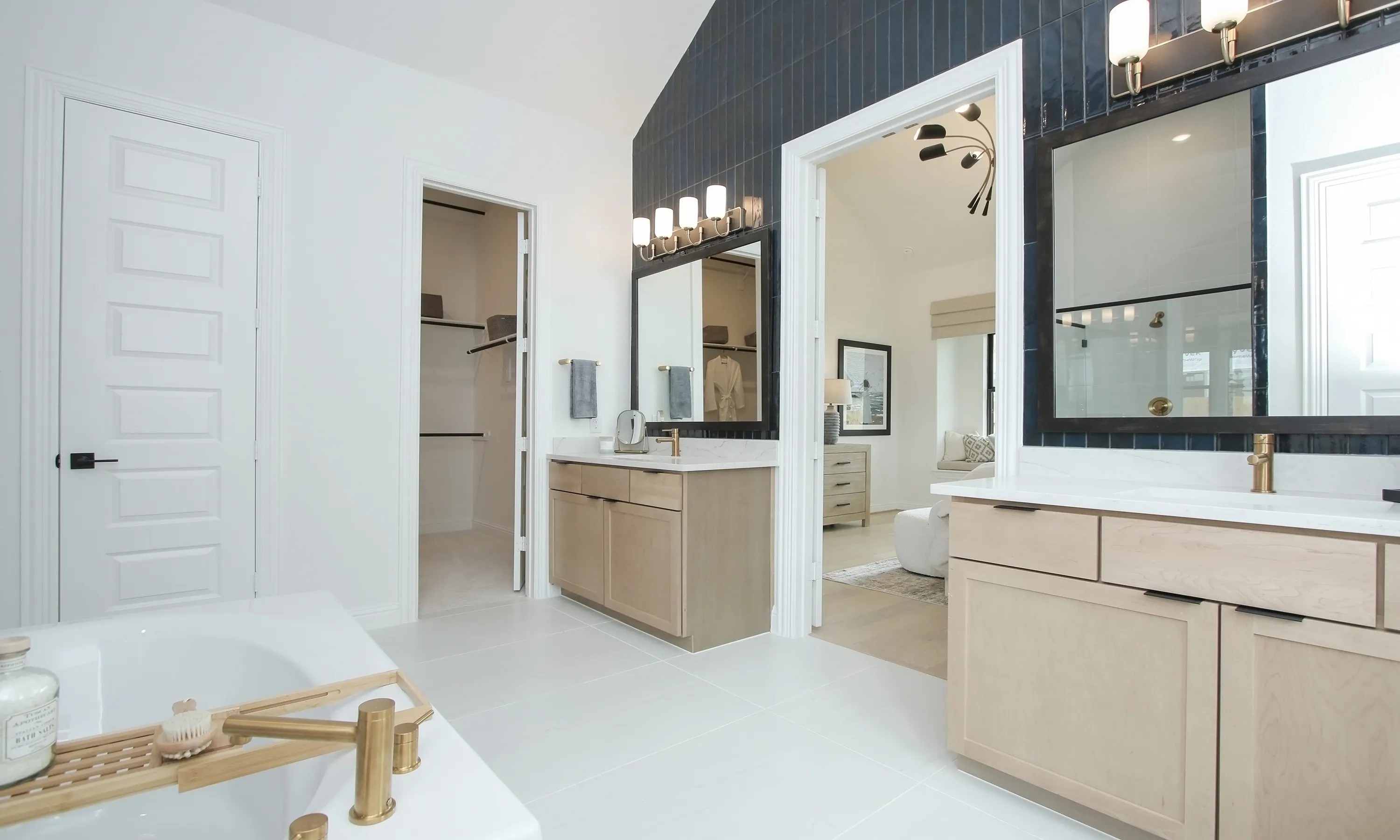 Elegant modern bathroom with dual vanities, gold fixtures, in Coastal Point community home.