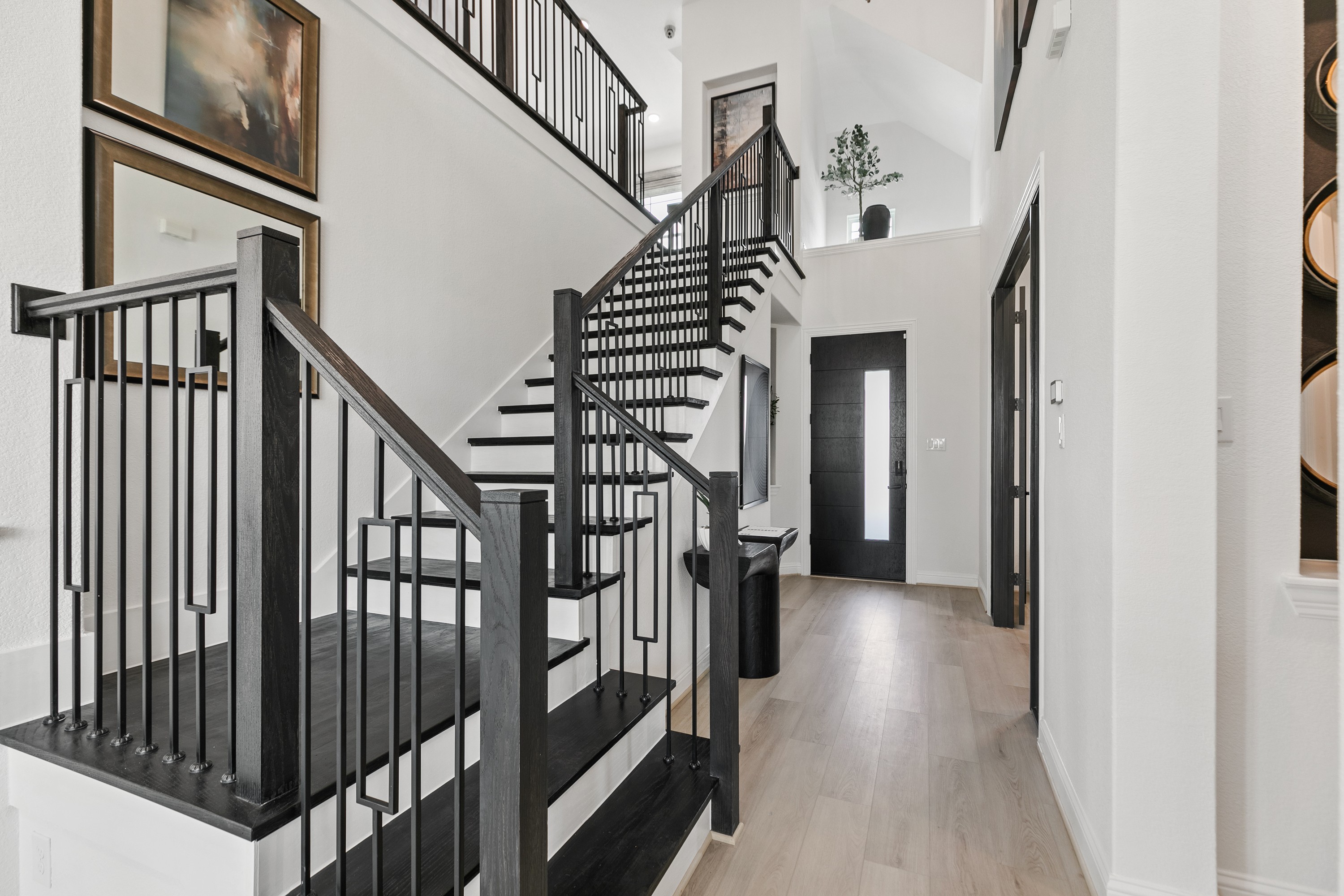 Elegant staircase with dark wood railing in modern Park at Eldridge home entryway.