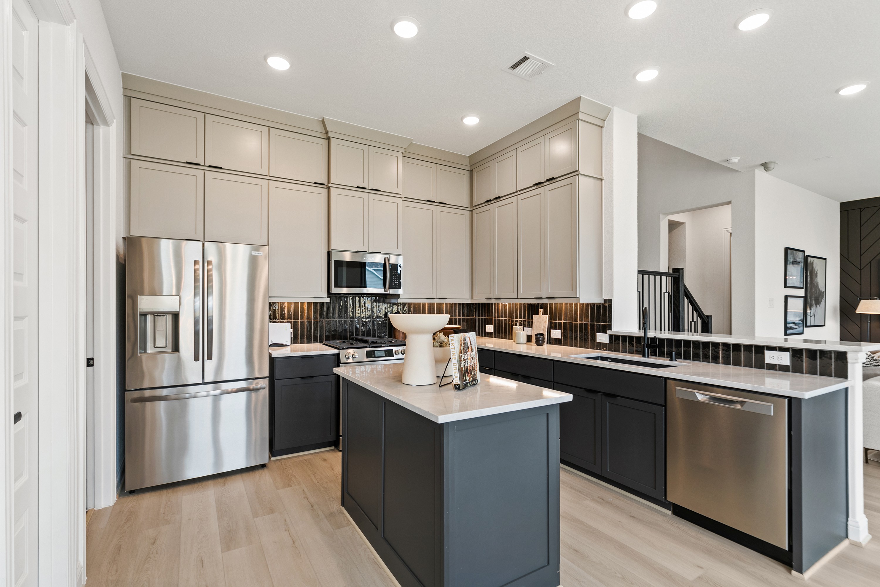 Modern kitchen with sleek cabinetry, stainless steel appliances, and island in Park at Eldridge, Houston.