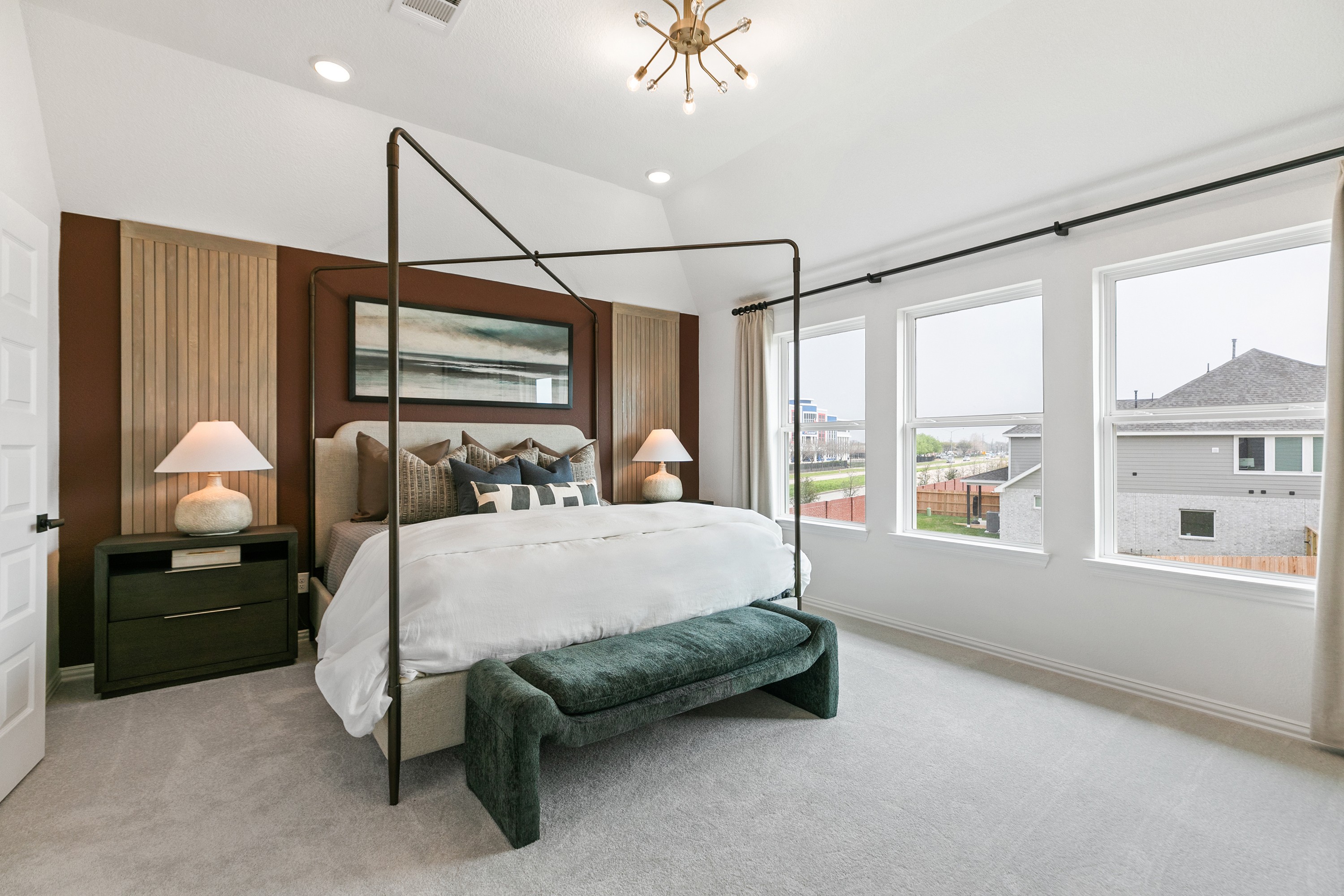 Elegant bedroom with canopy bed, panoramic windows, and modern lighting in Park at Eldridge community.