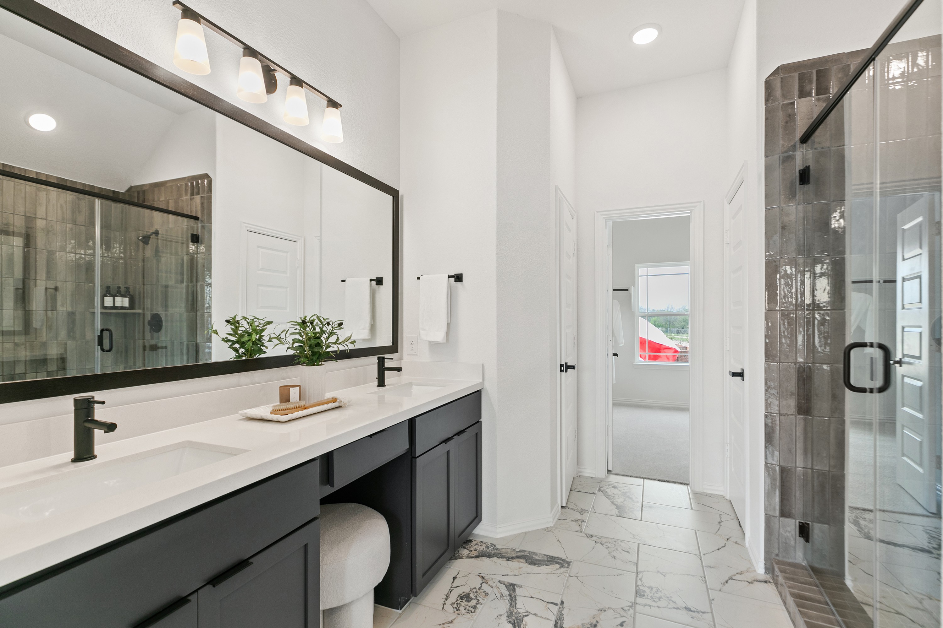 Luxurious bathroom with marble floor, dual vanity, modern fixtures, and glass shower in Park at Eldridge, Houston.