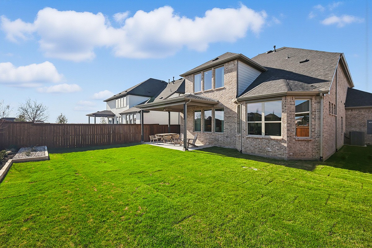 Spacious single-family home with modern design and architecture in a residential area, featuring a large backyard.