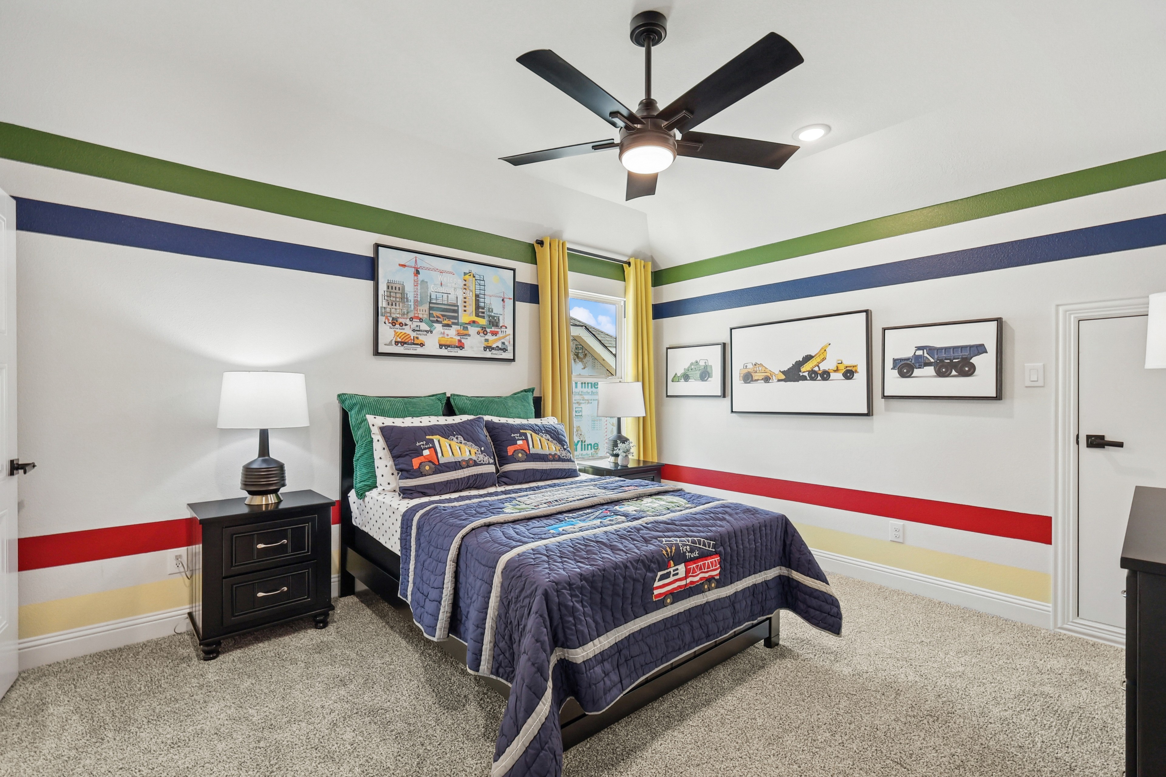 Vibrant kid's room with striped walls, construction-themed decor, and ceiling fan in Green Meadows, luxury home.