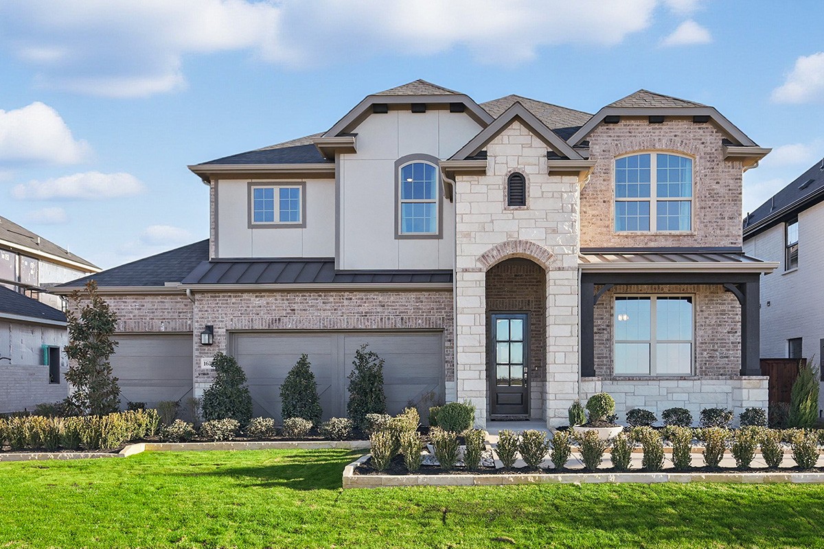Two-story brick and stone house with manicured lawn in Green Meadows. Modern design, large windows, Texas setting.