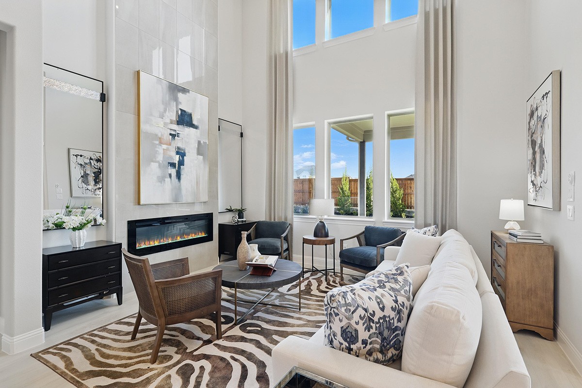 Spacious living room with high ceilings, modern fireplace, abstract art, large windows, at Green Meadows.