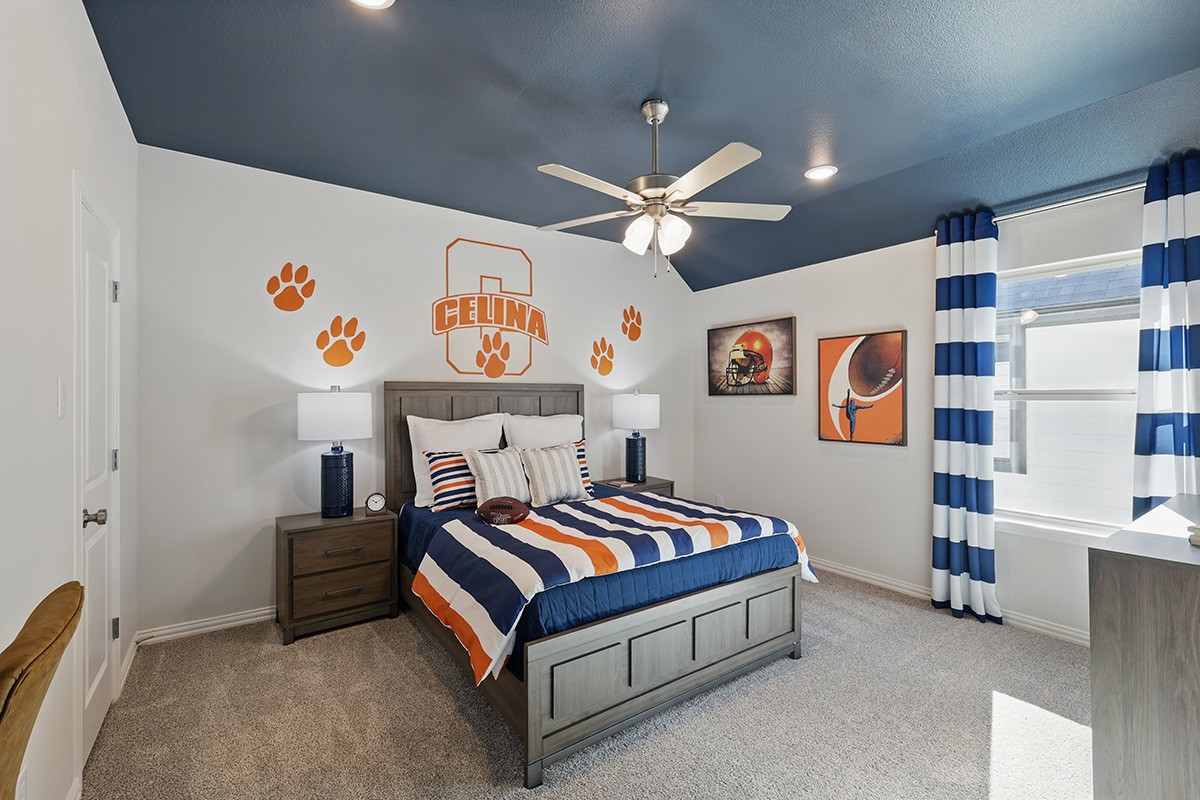 Celina-themed bedroom with striped bedding, blue ceiling, wall art in Green Meadows community.