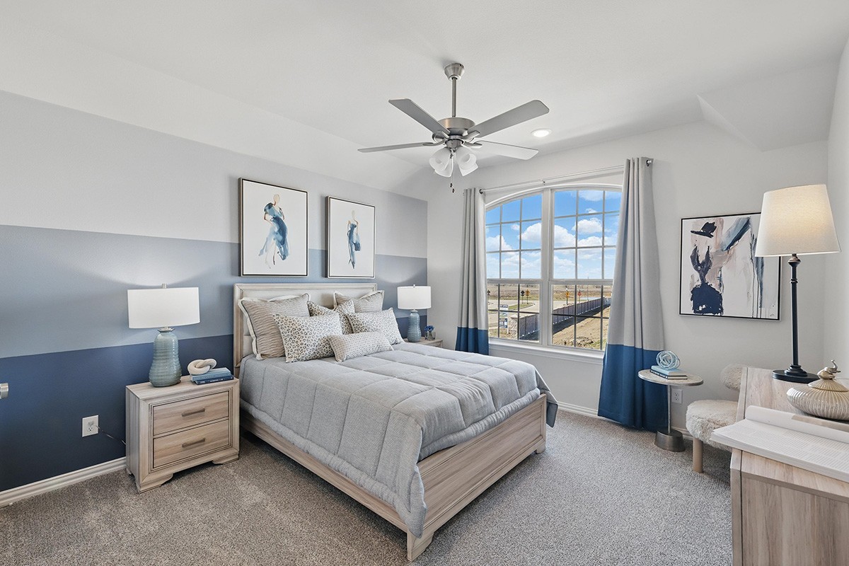 Elegant bedroom in Green Meadows with large arched window, modern decor, and soft blue-gray tones.