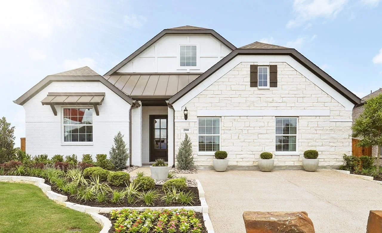 Modern single-story brick home with stone facade, gabled roof, landscaped garden in Thompson Farms community.
