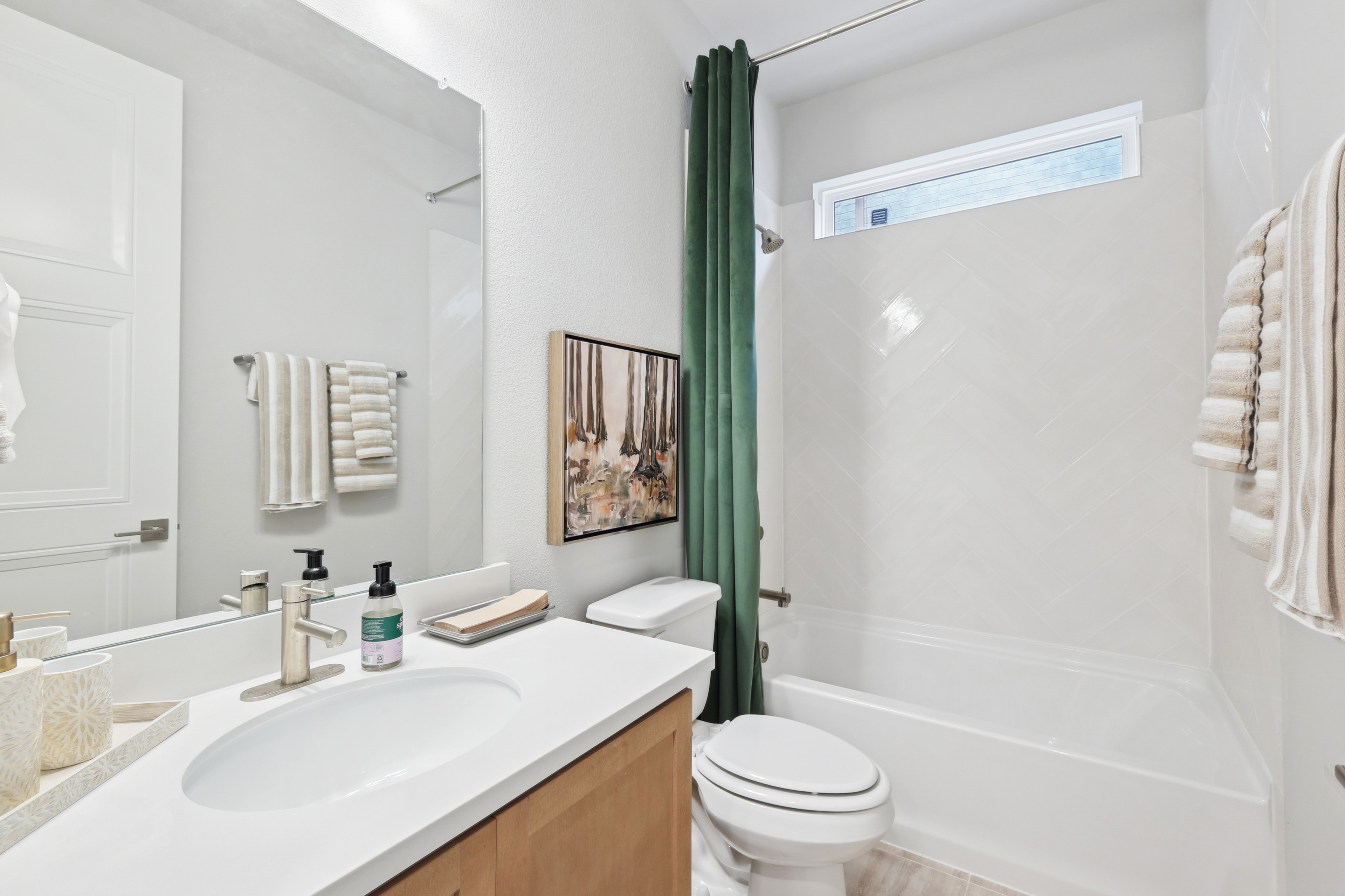 Elegant bathroom with modern vanity, herringbone tiles, art, Wildflower Ranch, spacious design.