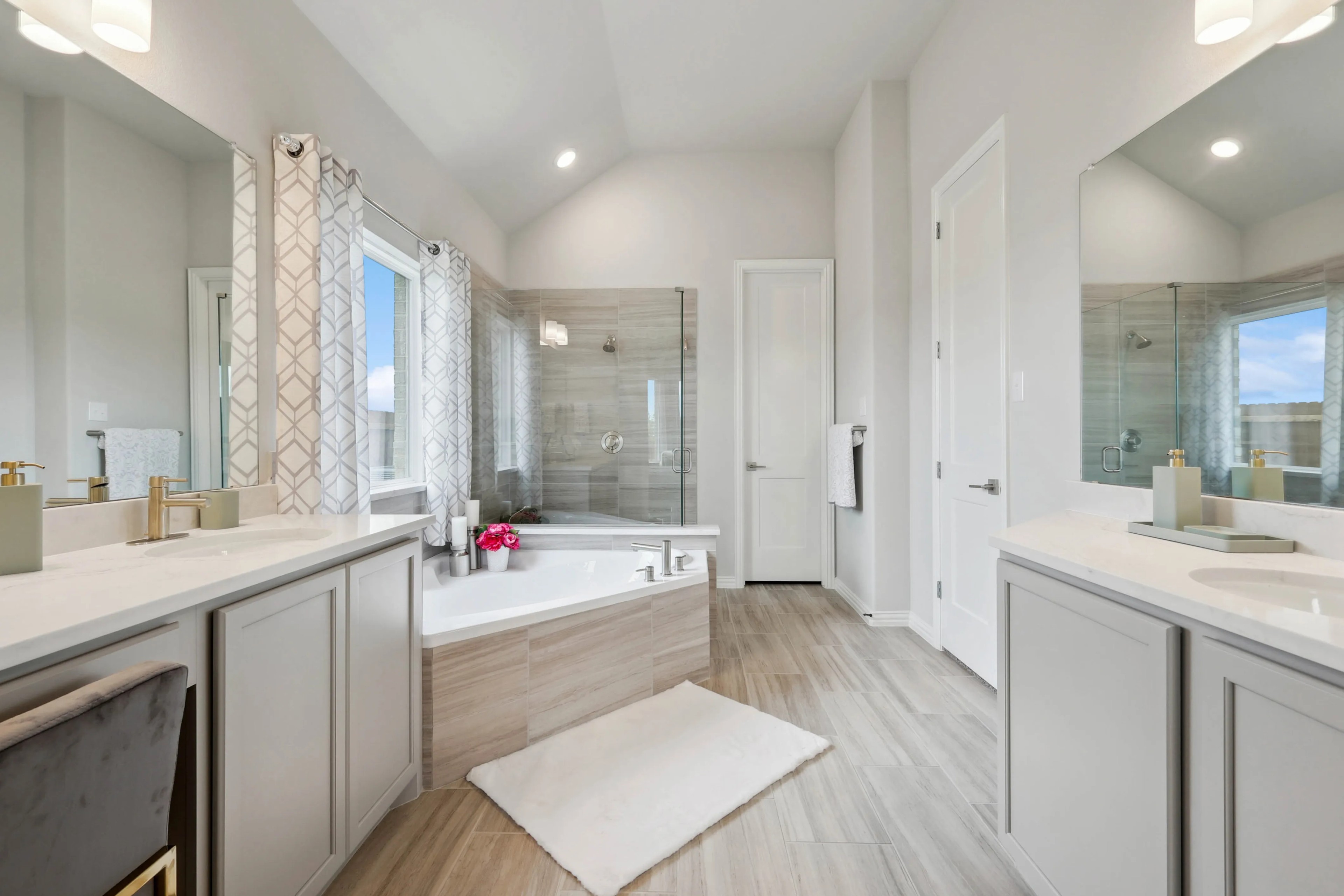 Luxurious bathroom with corner tub, glass shower, and modern fixtures in Hulen Trails. Neutral tones, ample natural light.