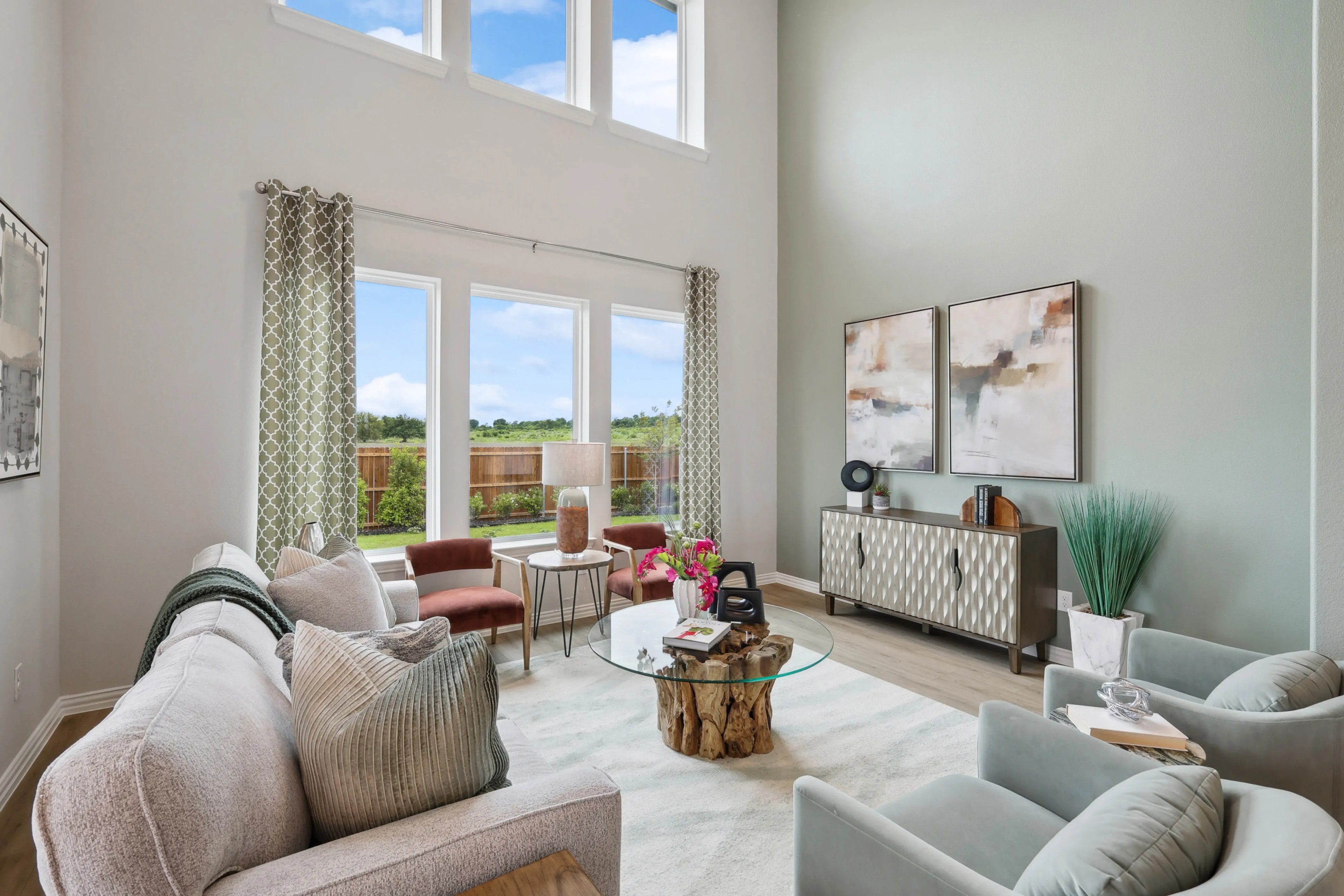 Spacious modern living room with tall windows, elegant decor, and neutral tones, in Hulen Trails, Texas.