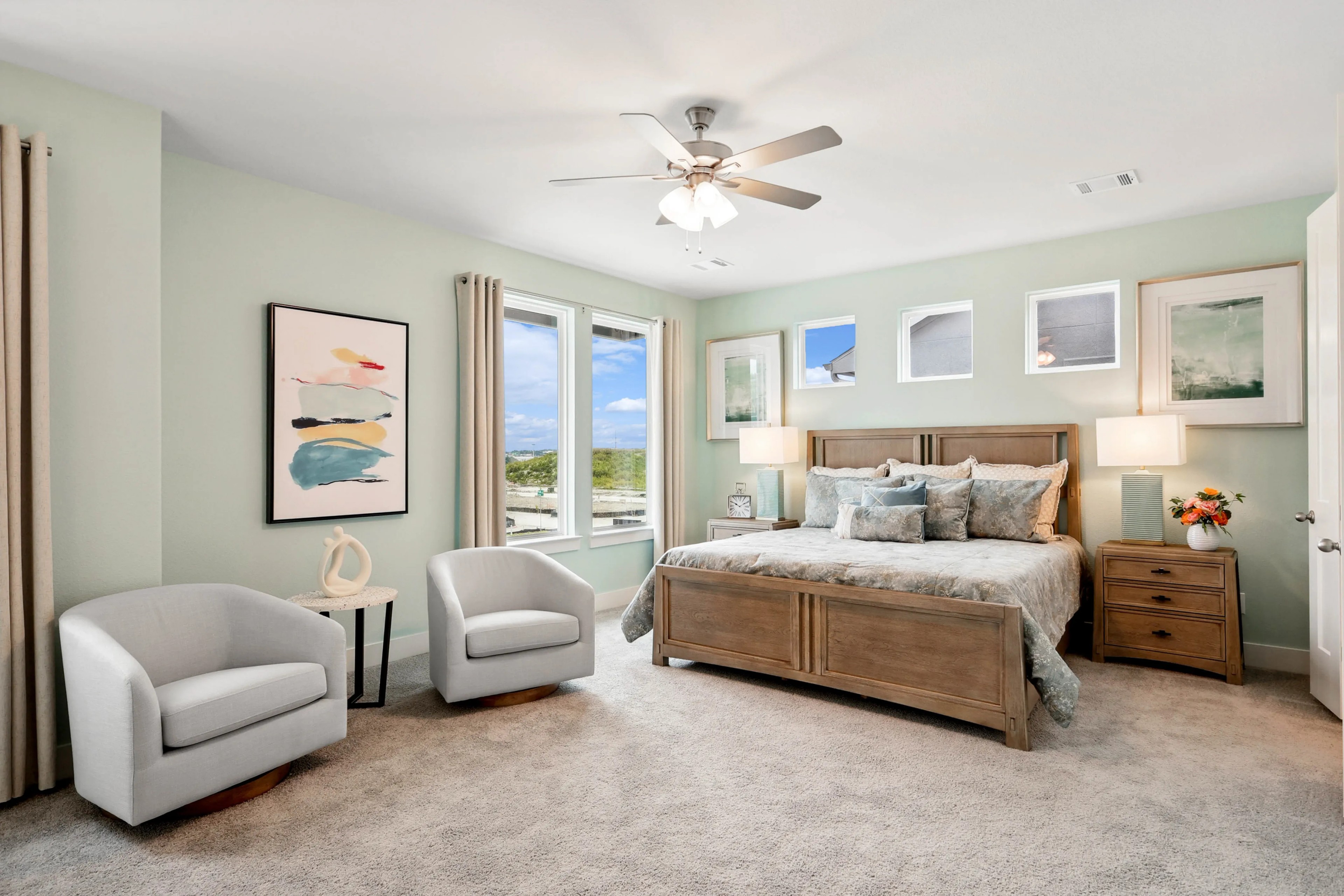 Elegant bedroom with wooden bed, large windows, modern art. Neutral tones. Collin Creek, suburban luxury.