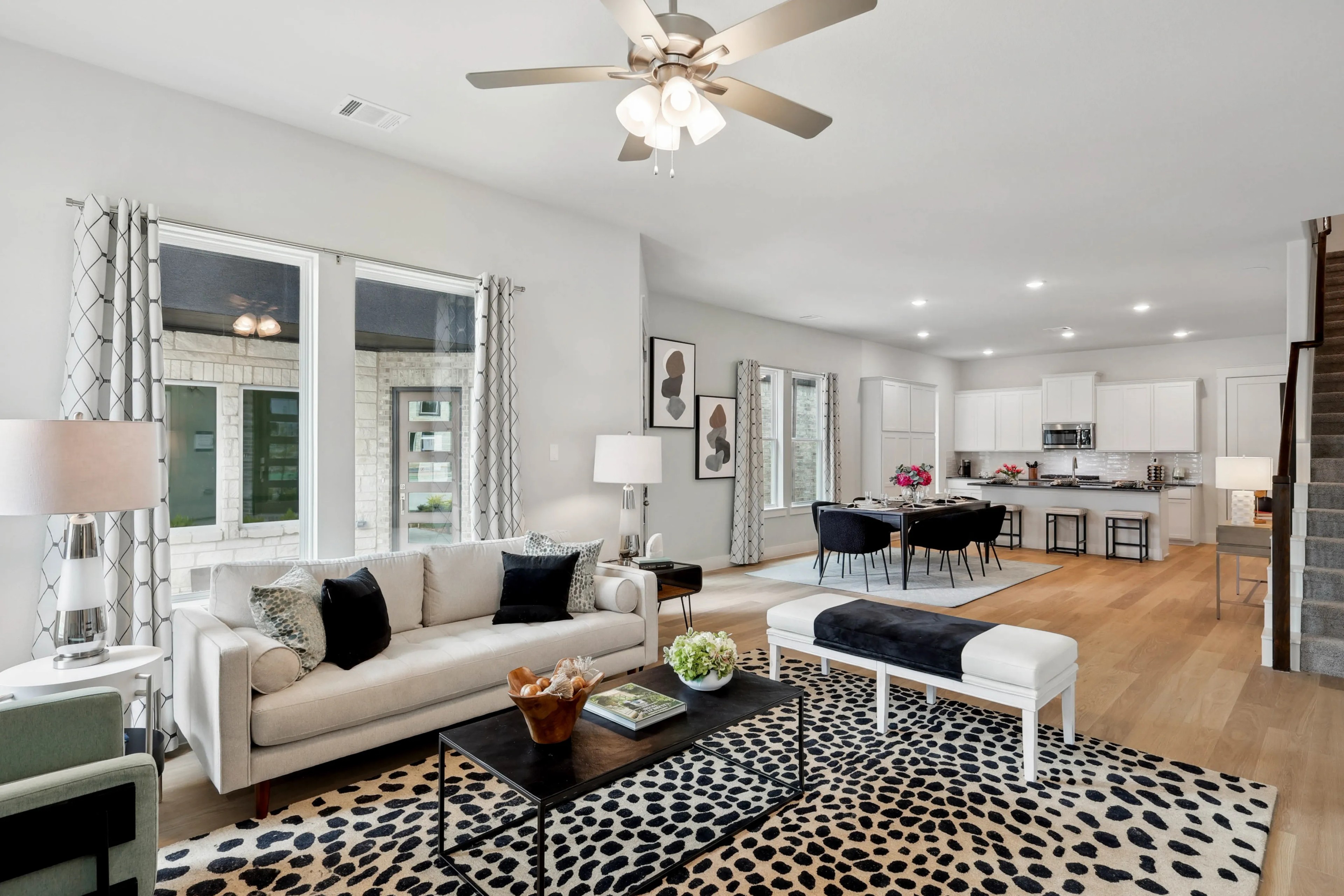 Stylish modern living room with plush furniture, open kitchen, in Collin Creek community.