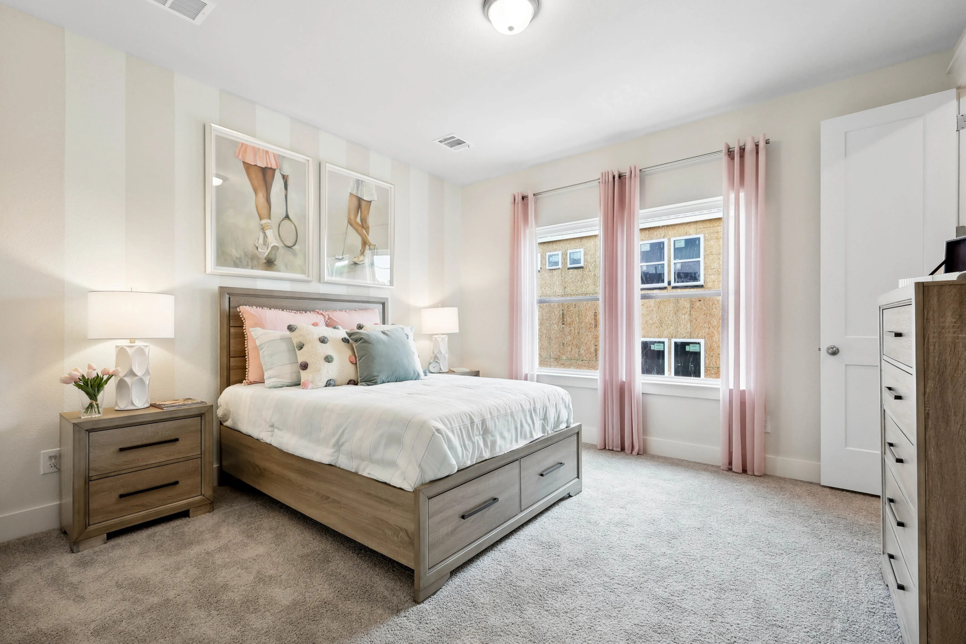 Elegant bedroom with striped wall, pastel decor, large windows, pink curtains in Collin Creek community.