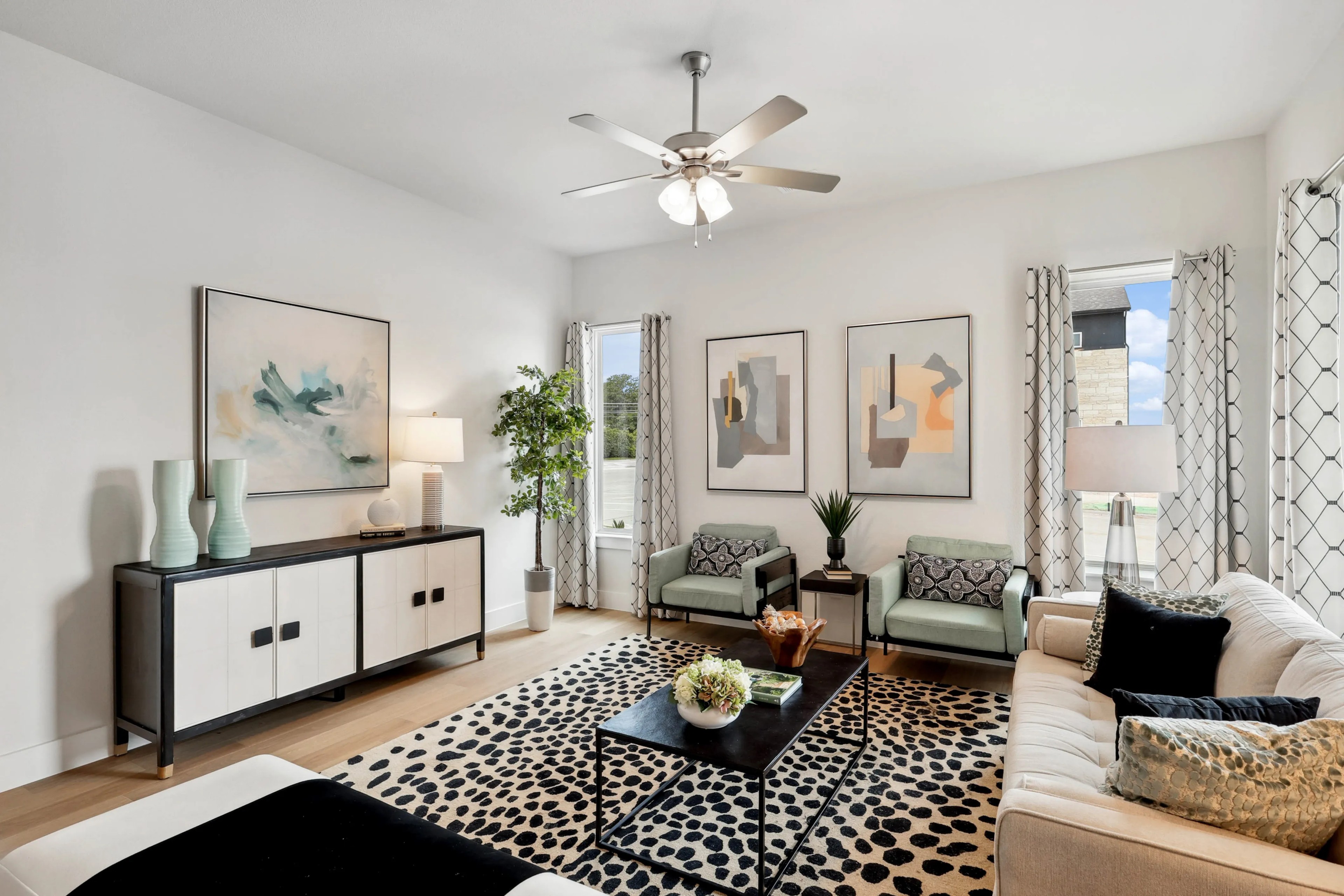 Modern living room with abstract art, cozy seating, stylish rug, in Collin Creek community home.