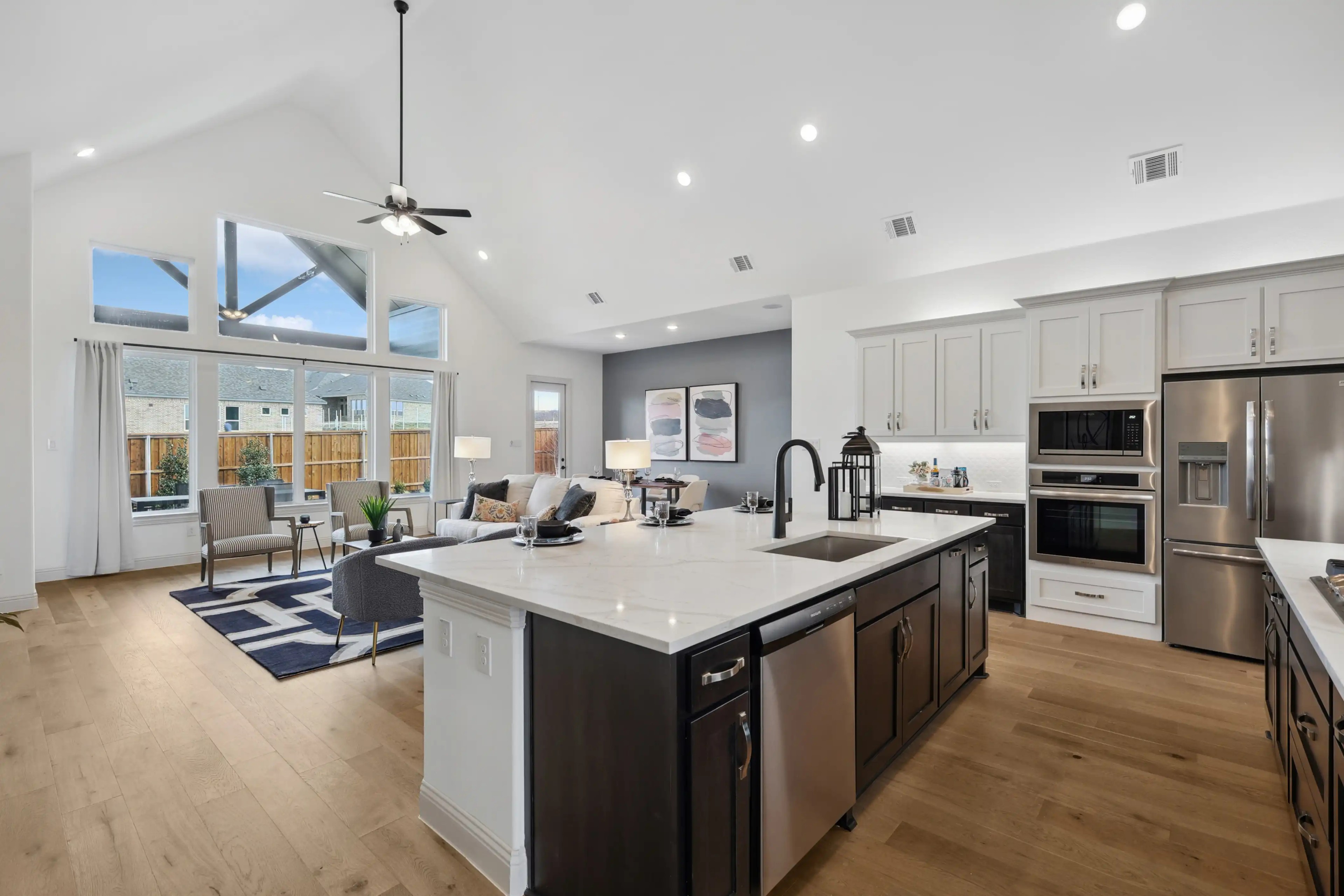 Open-concept kitchen-living area with high ceilings, island, and natural light in Westside Preserve.