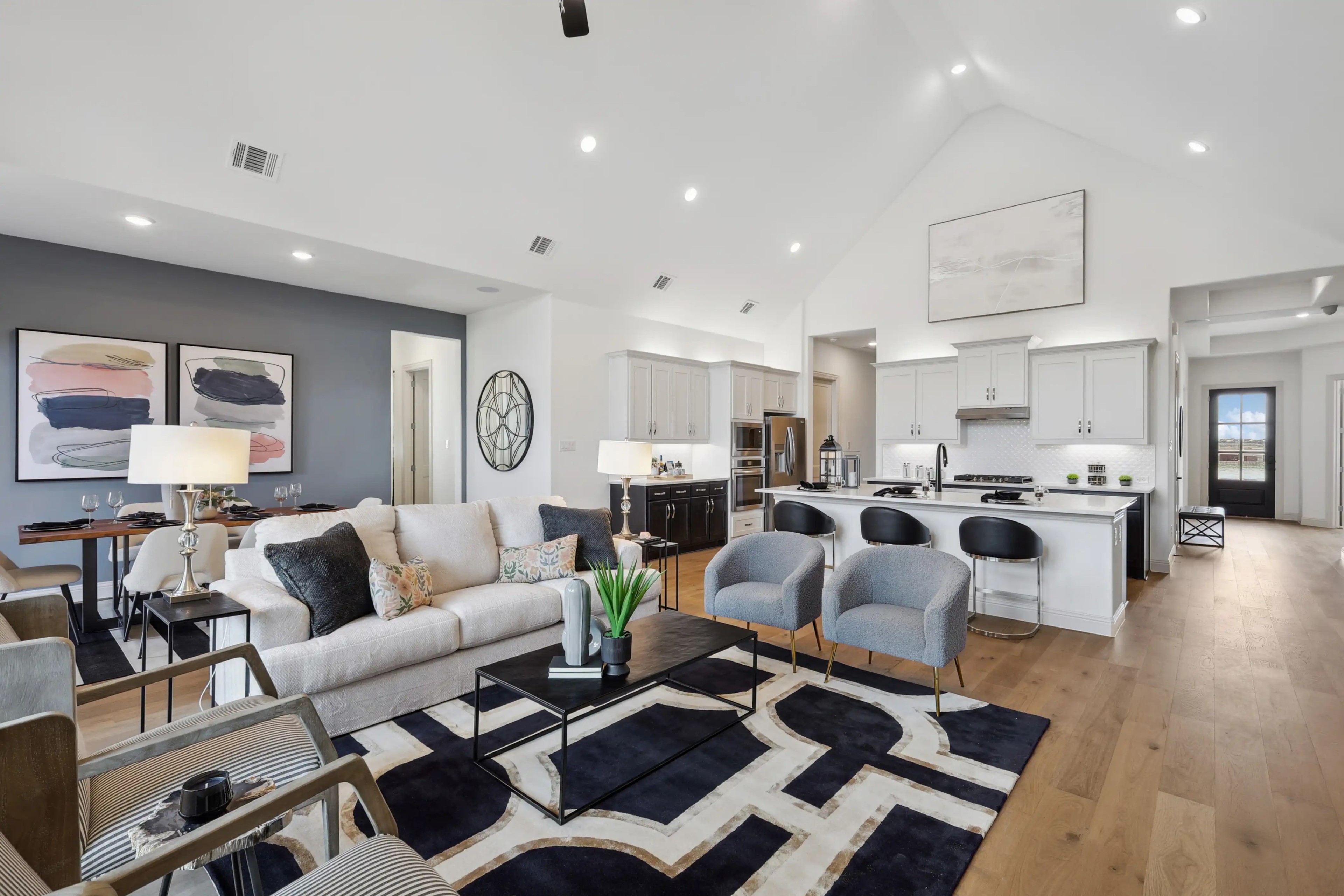 Modern open-concept living room and kitchen with high ceilings, elegant furnishings, in Westside Preserve.