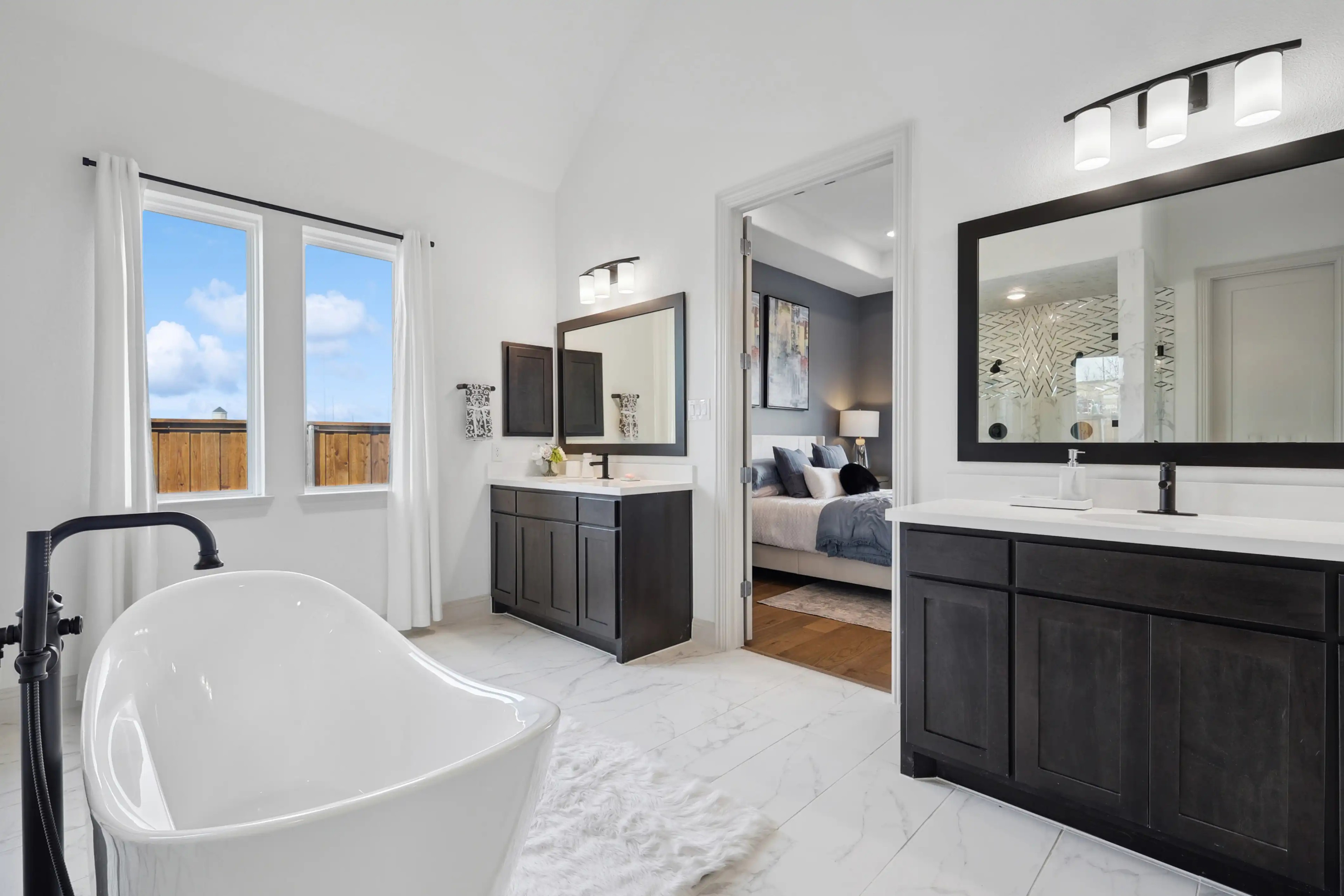 Spacious bathroom with freestanding tub, dual vanities, modern decor in Westside Preserve home.