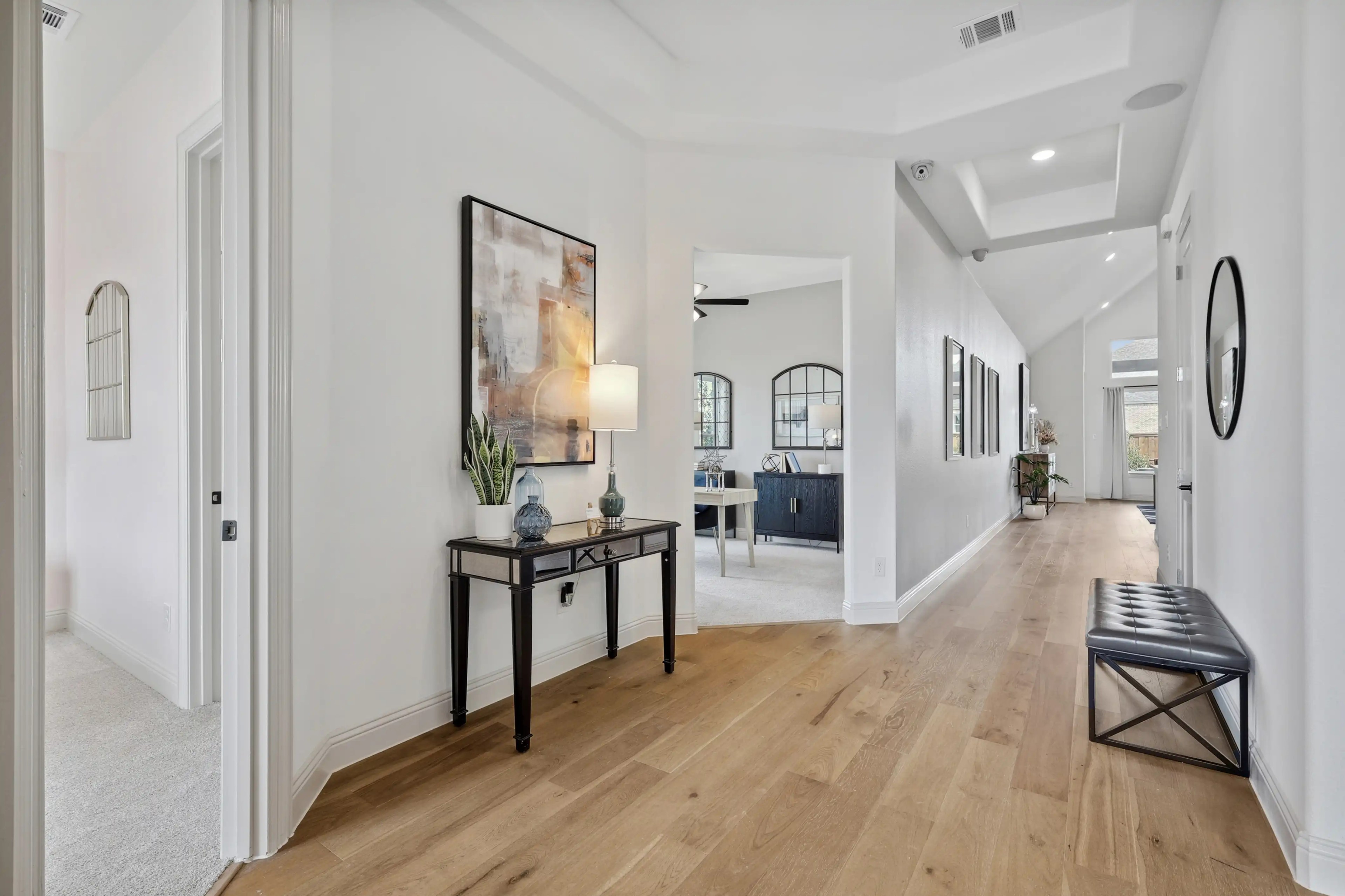 Elegant hallway in luxury Westside Preserve home with hardwood floors, recessed lighting, and modern decor.