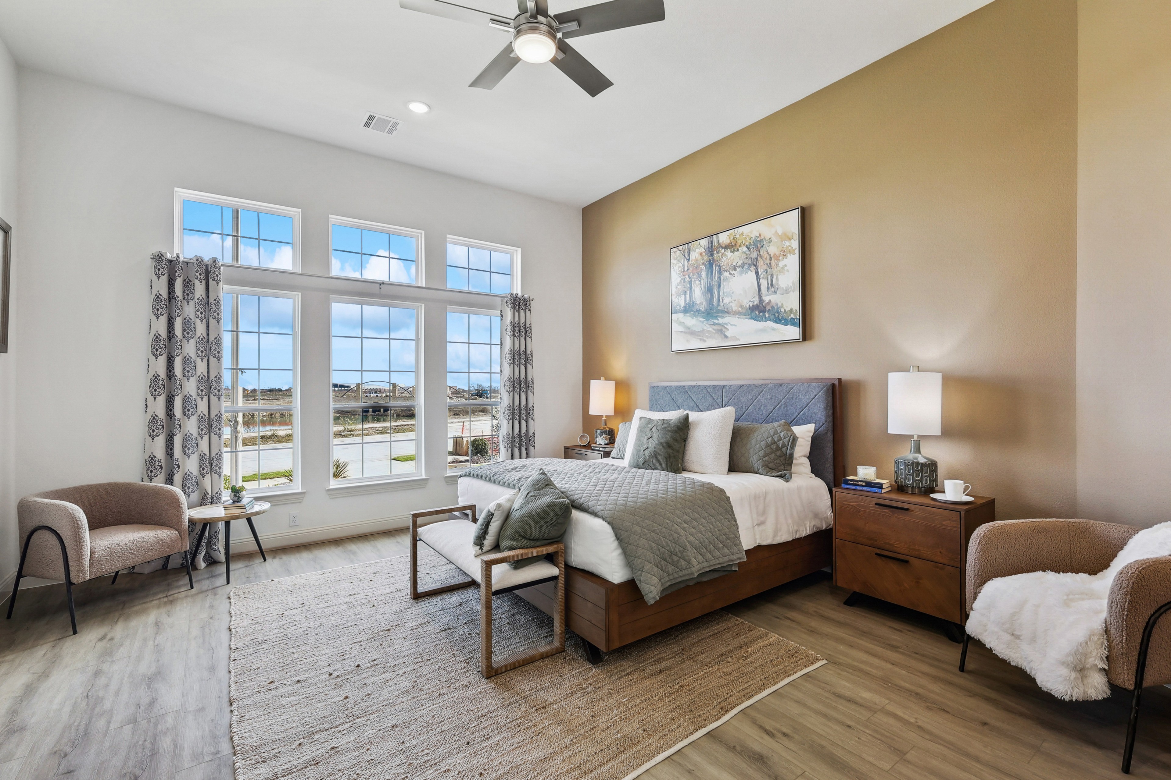 Spacious bedroom with large windows, hardwood floors, luxury decor in Solterra, Texas.