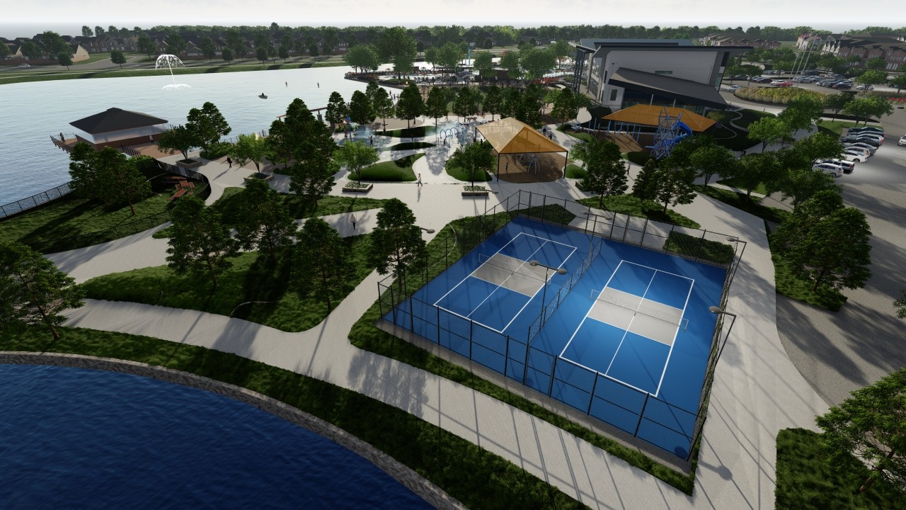 Aerial view of Solterra community park in Texas with tennis courts, lake, and pavilions amidst lush greenery.