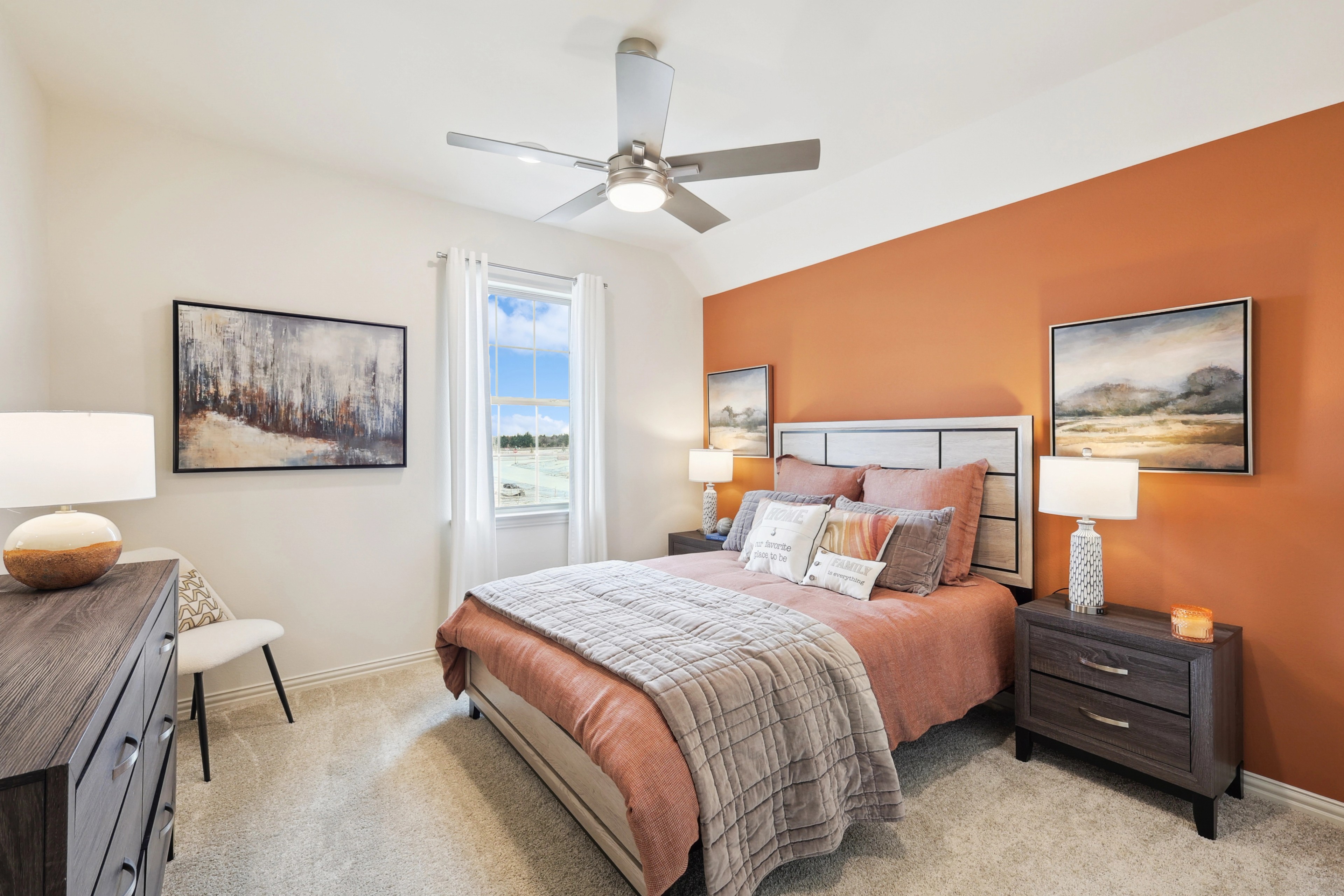 Luxurious bedroom with orange accent wall, elegant decor in The Oaks community.