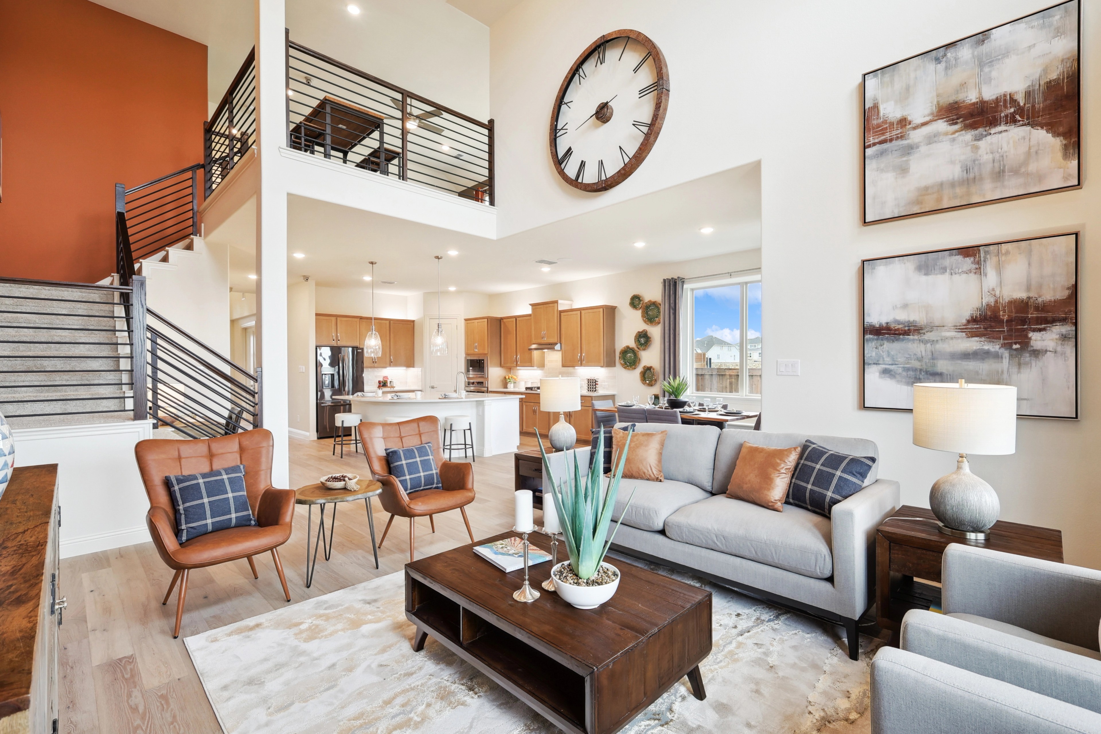 Luxury modern living room with open floor plan, elegant decor, large clock, and balcony in The Oaks.