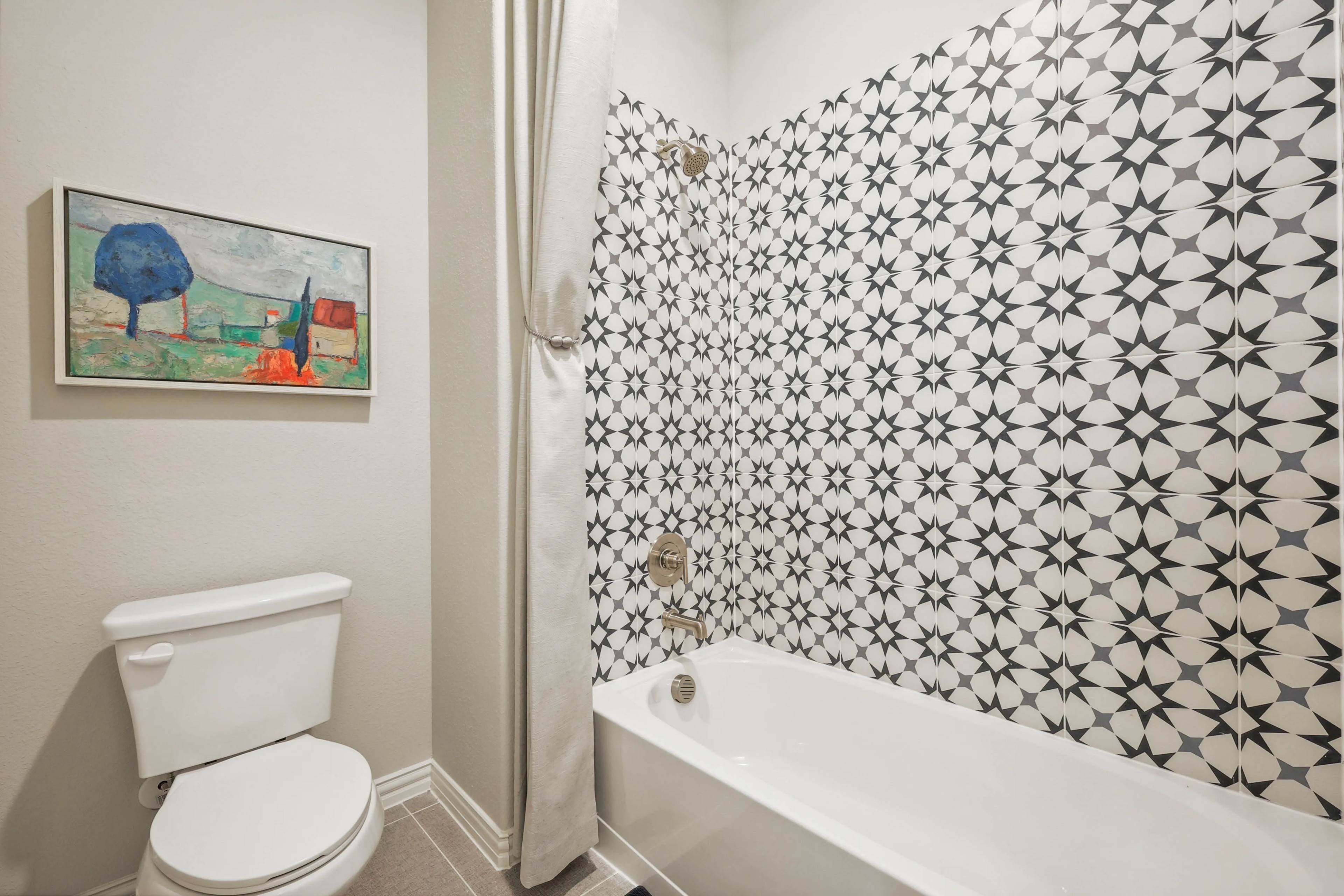Modern bathroom with geometric tile pattern and abstract art. Pebblebrook community.