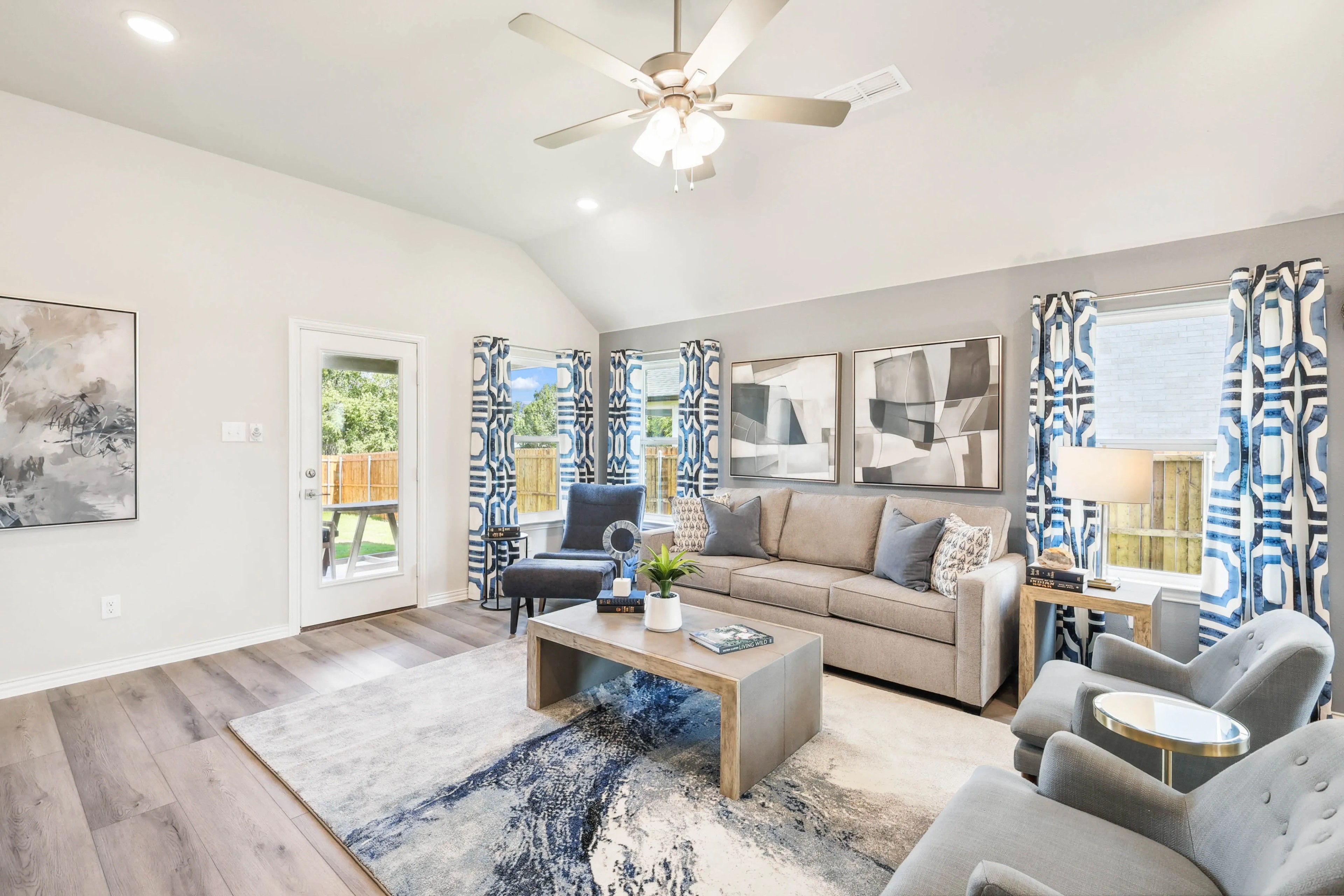 Spacious living room, neutral tones, geometric decor, large windows, Pebblebrook community, elegant furniture, natural light.