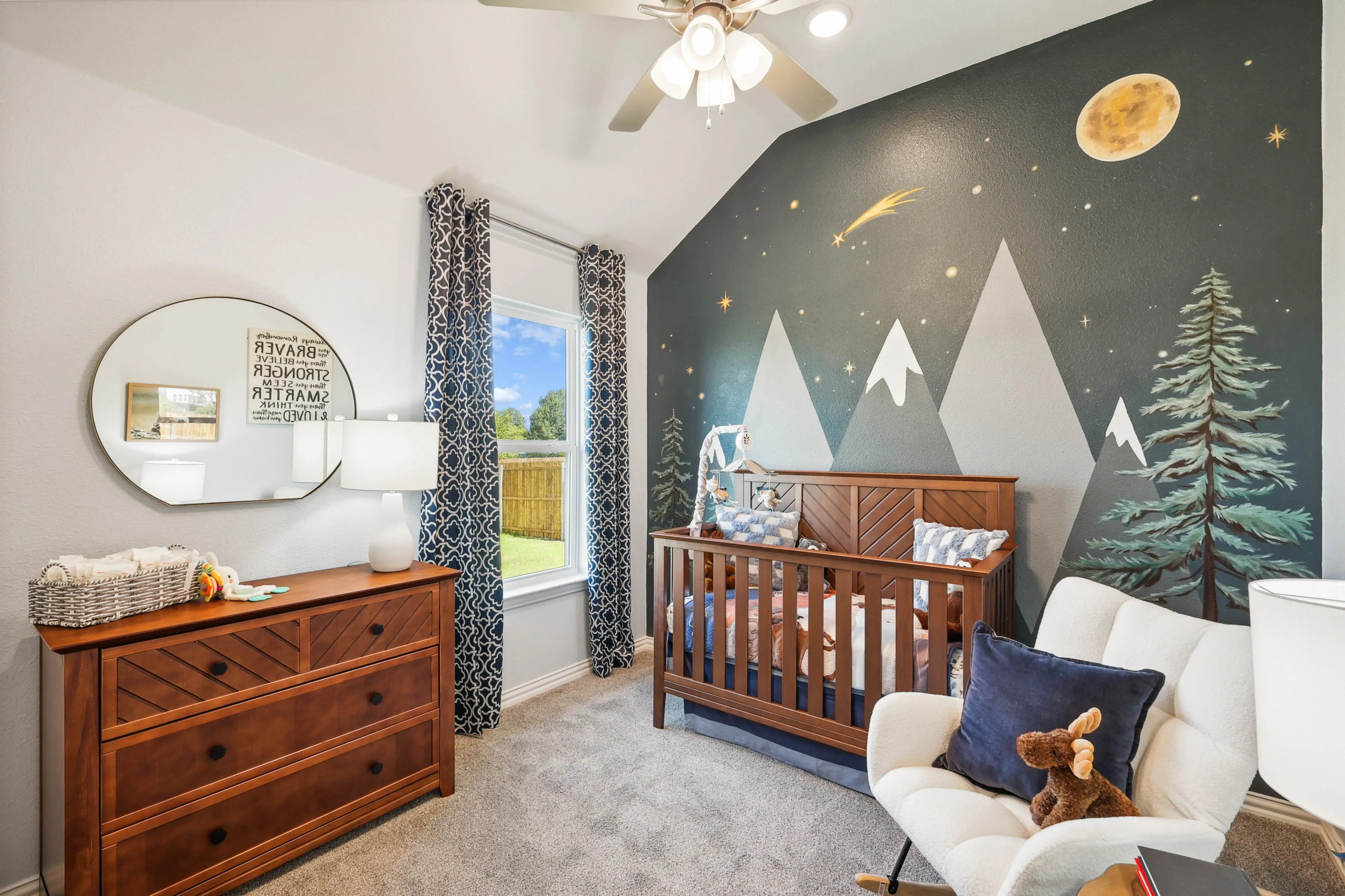 Stylish nursery with mountain mural, dark wood crib, dresser, Pebblebrook community.