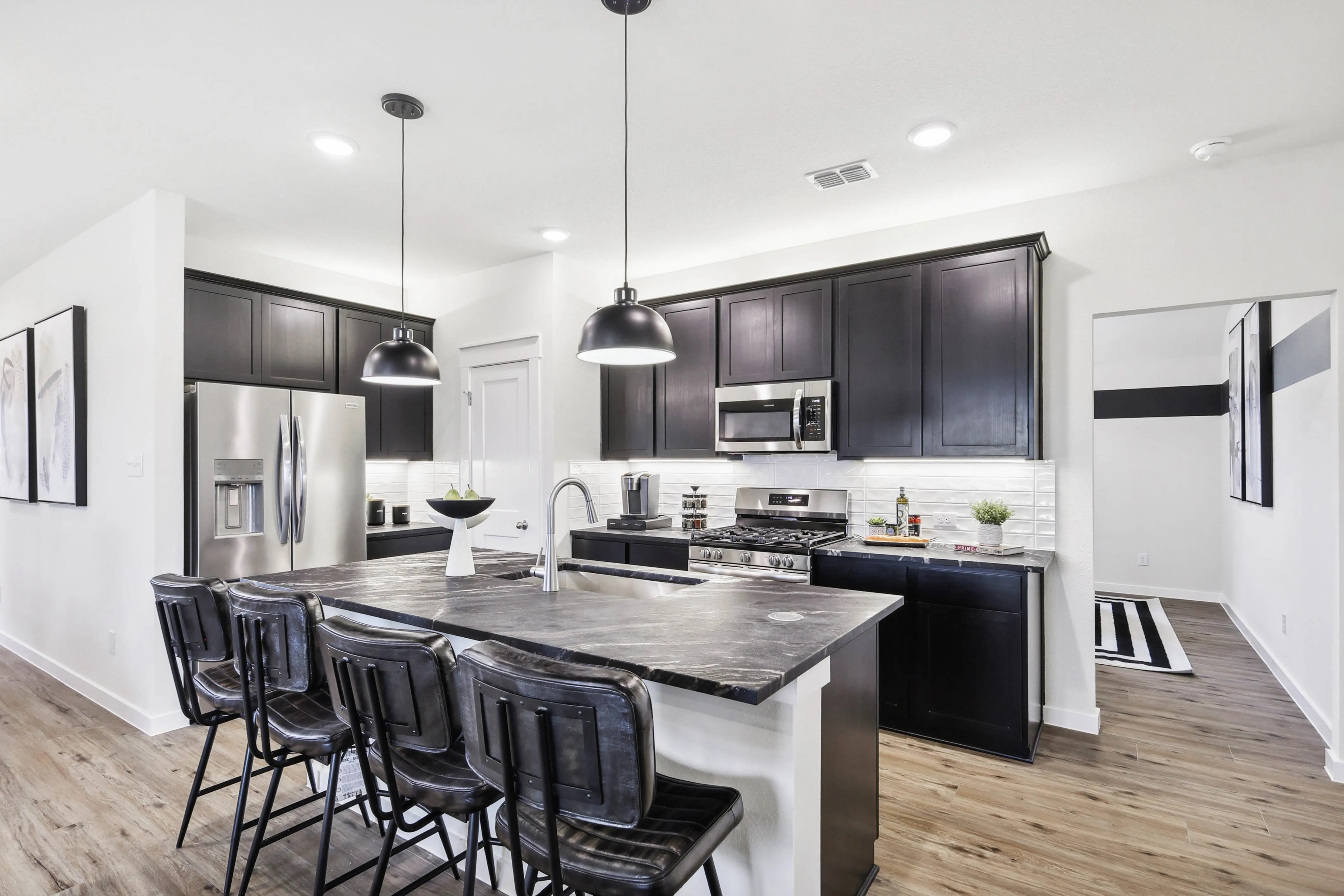 Elegant kitchen island, dark cabinets, stainless steel appliances, in Simpson Crossing, modern design.