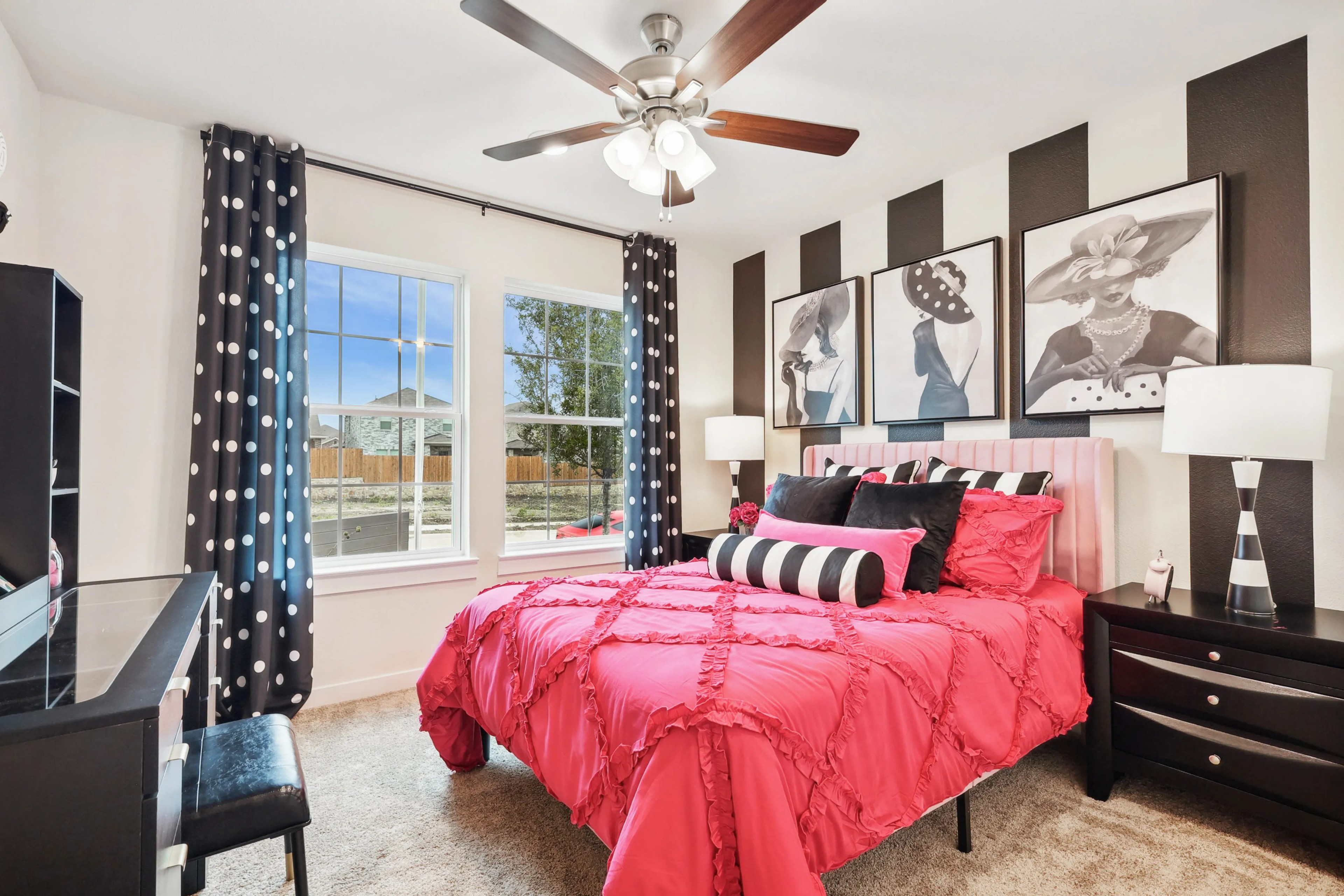 Vibrant bedroom with pink bedding, striped art, polka dot curtains, large windows, Simpson Crossing community.