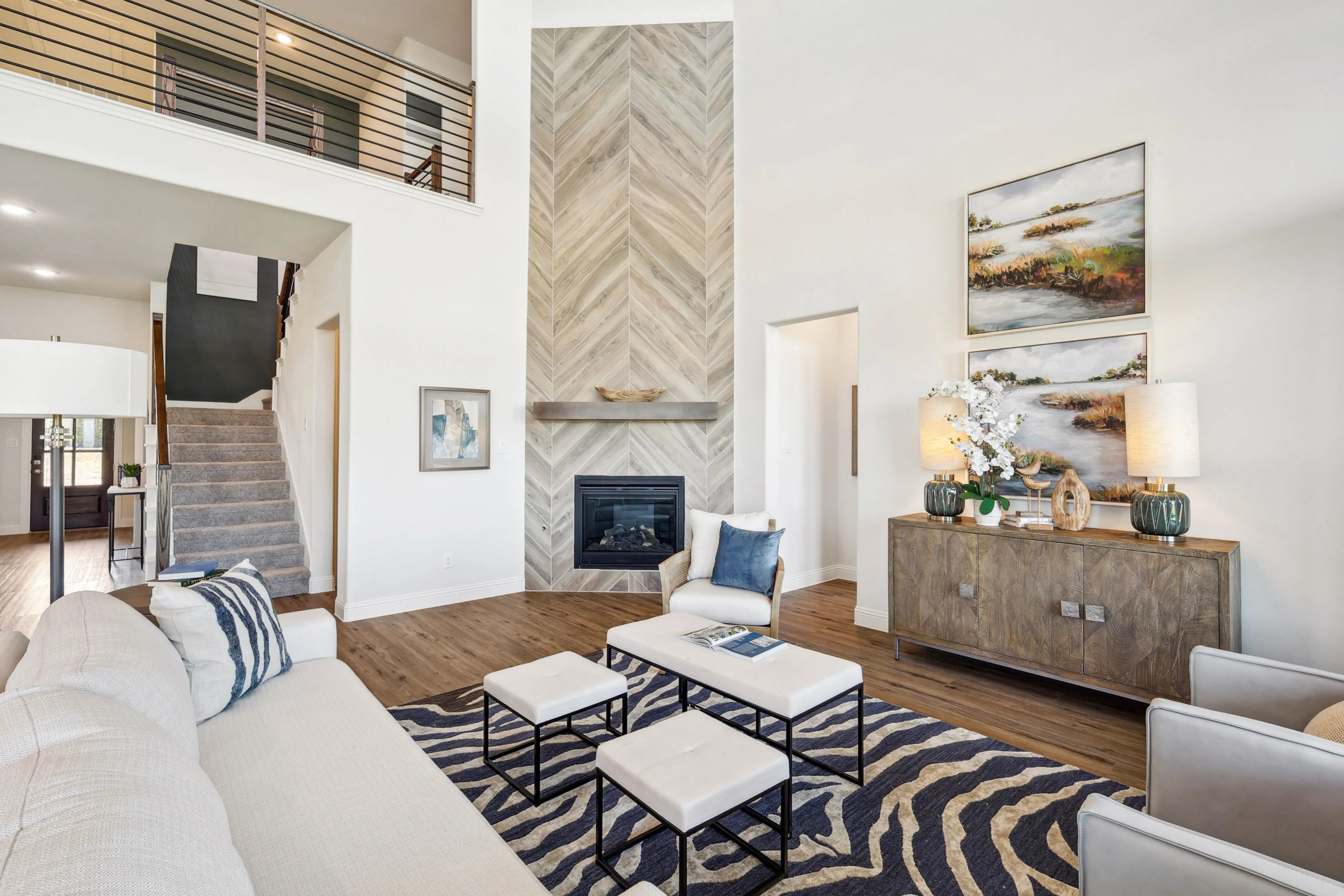 Spacious living room with herringbone fireplace, stylish decor, and staircase in Ridge Crossing.