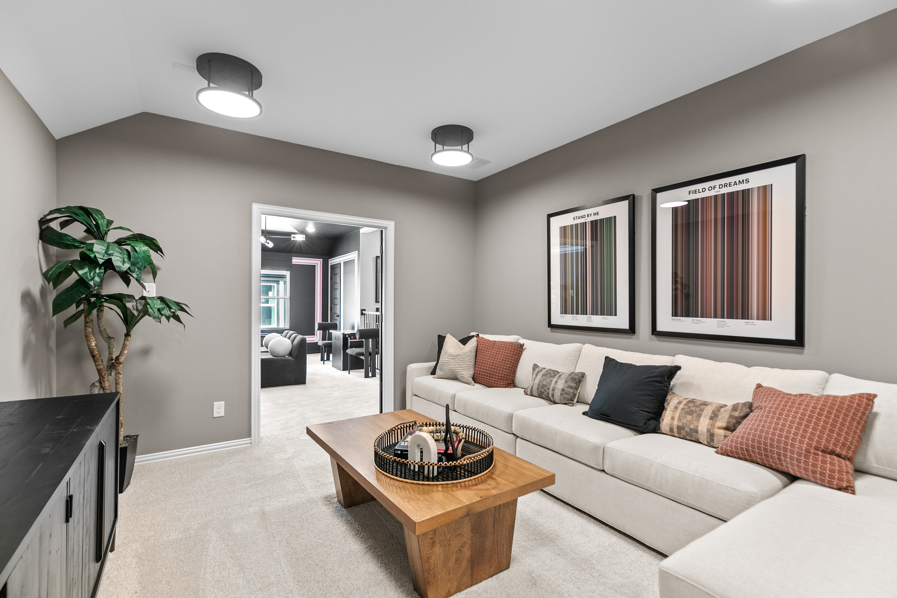 Modern living room with beige sectional sofa, framed art, wood table in River Ranch community.