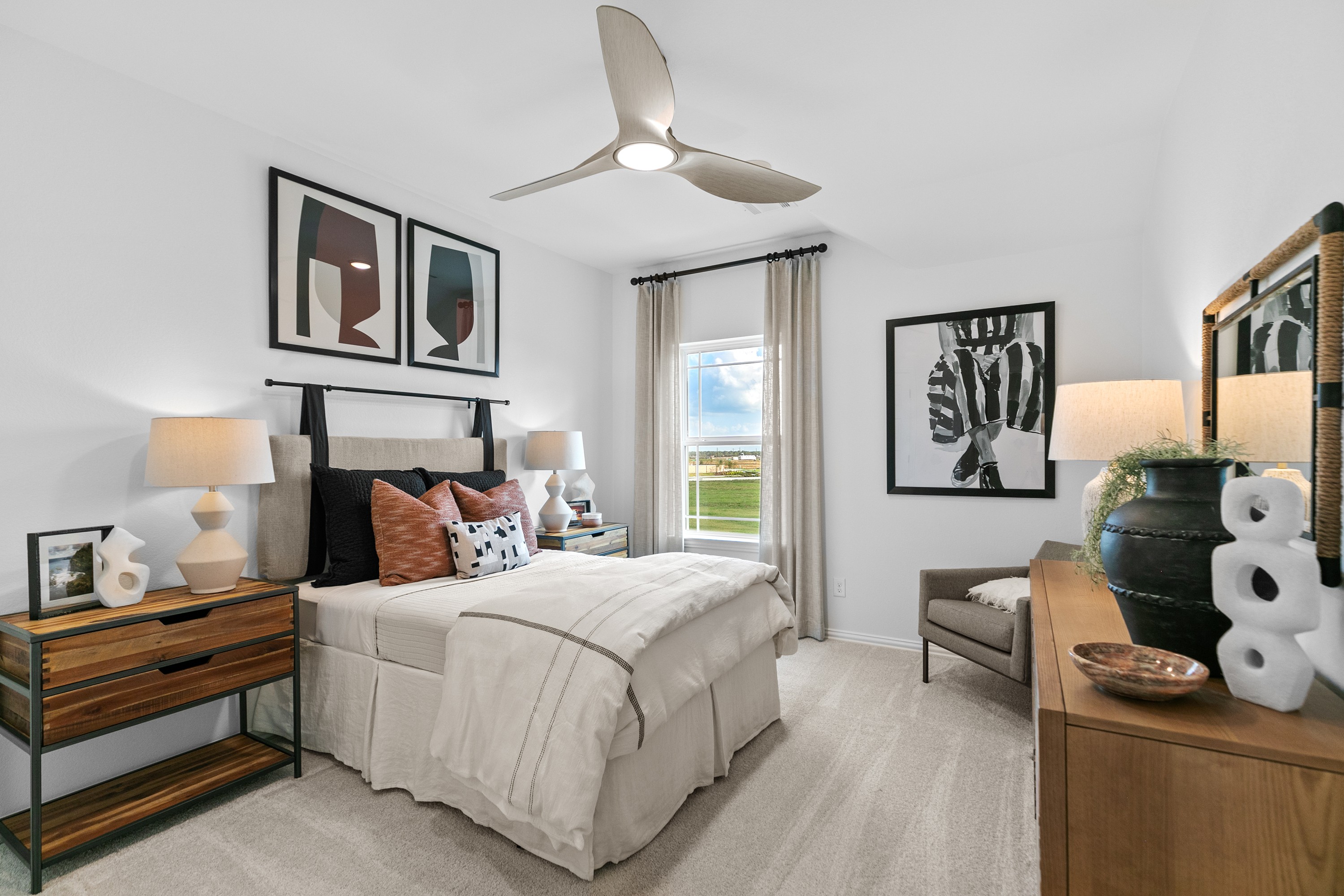 Elegant bedroom in River Ranch featuring modern art, minimalist furniture, and large window with scenic view.