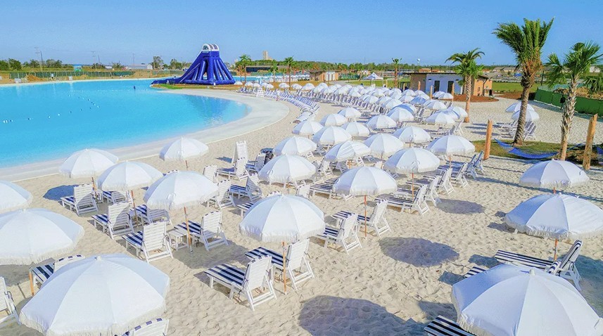 Luxury beach resort with white umbrellas, loungers, and large pool in River Ranch. Palm trees enhance tropical feel.