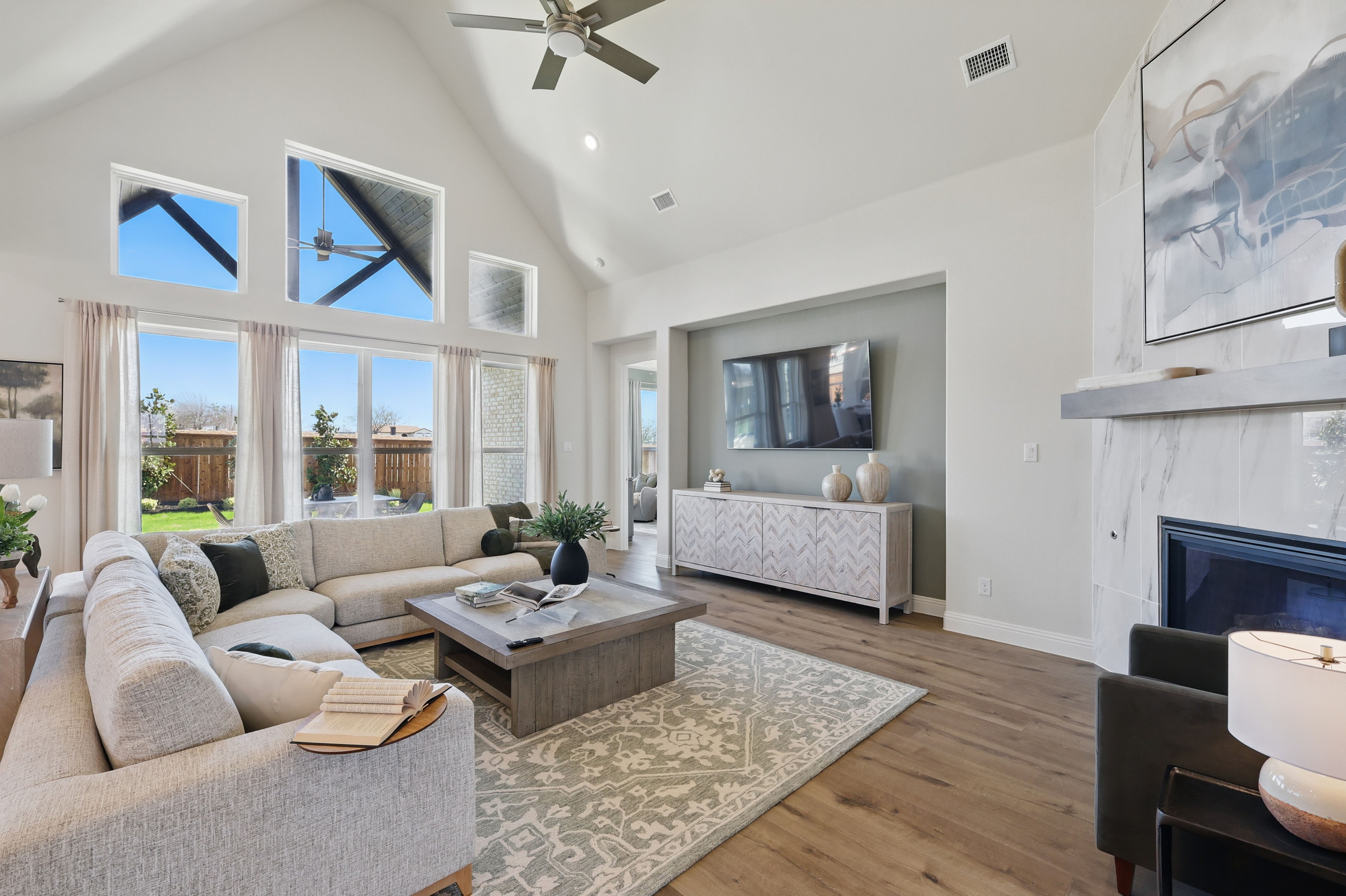 Spacious living room with vaulted ceiling, modern decor, large windows, elegant fireplace, Rio Vista at Kelly Ranch.