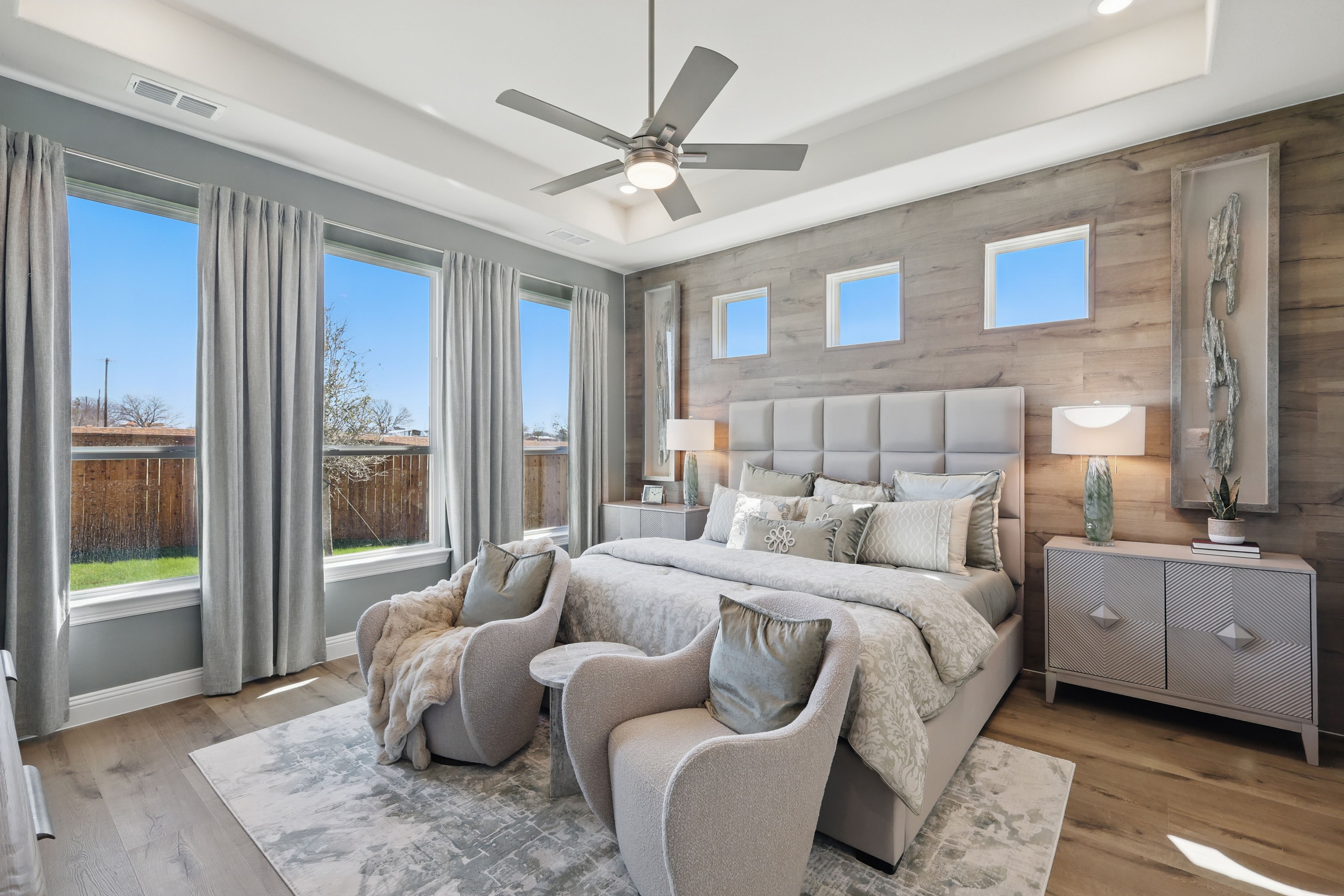 Luxurious bedroom at Rio Vista Kelly Ranch; wood accent wall, plush bedding, large windows.