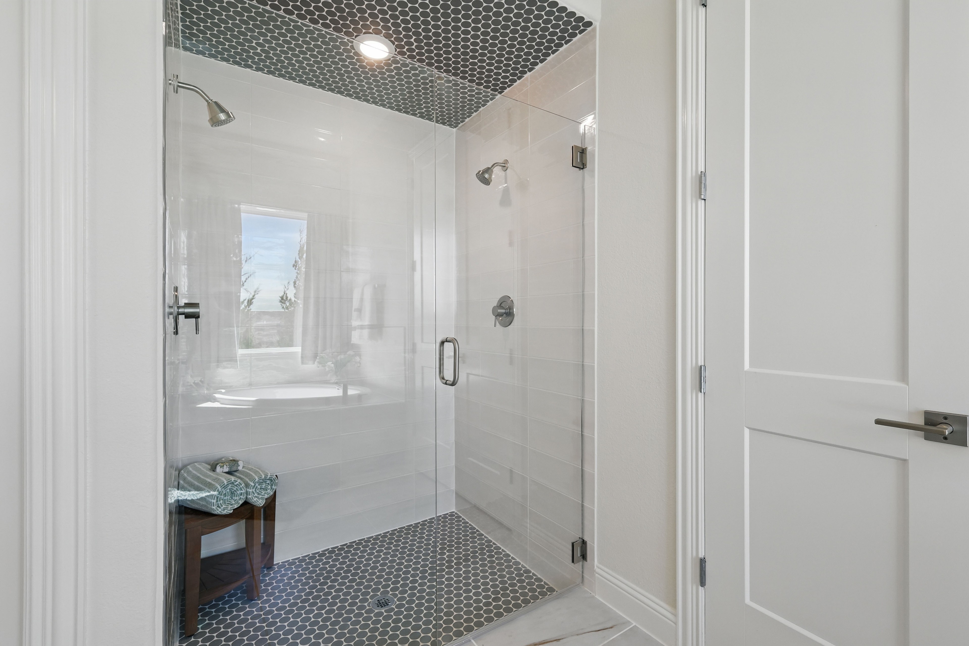 Elegant glass shower with hexagonal floor tiles and high-end fixtures in Rio Vista at Kelly Ranch.
