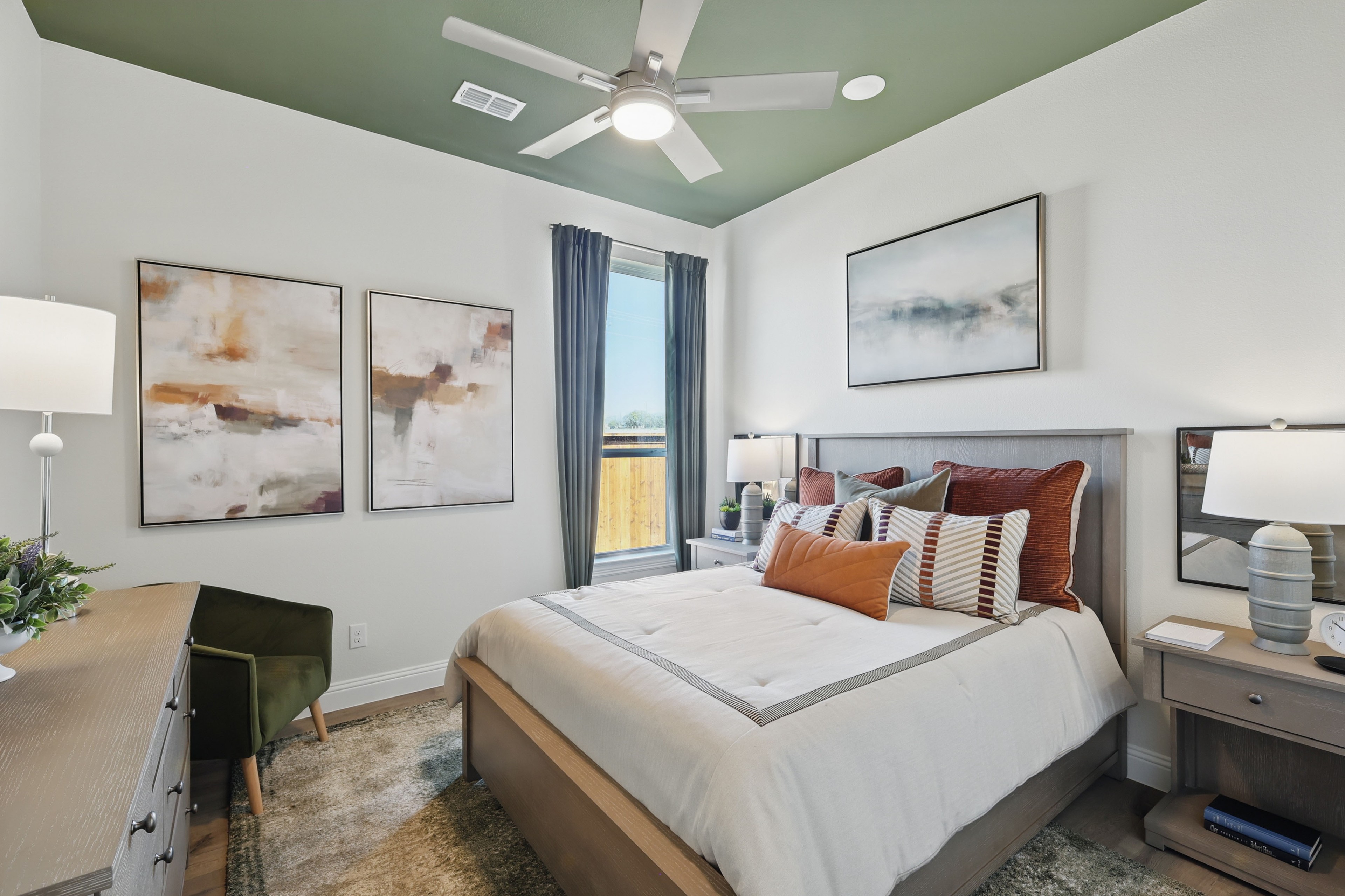 Stylish bedroom with modern decor, green ceiling, abstract art, in Rio Vista at Kelly Ranch.