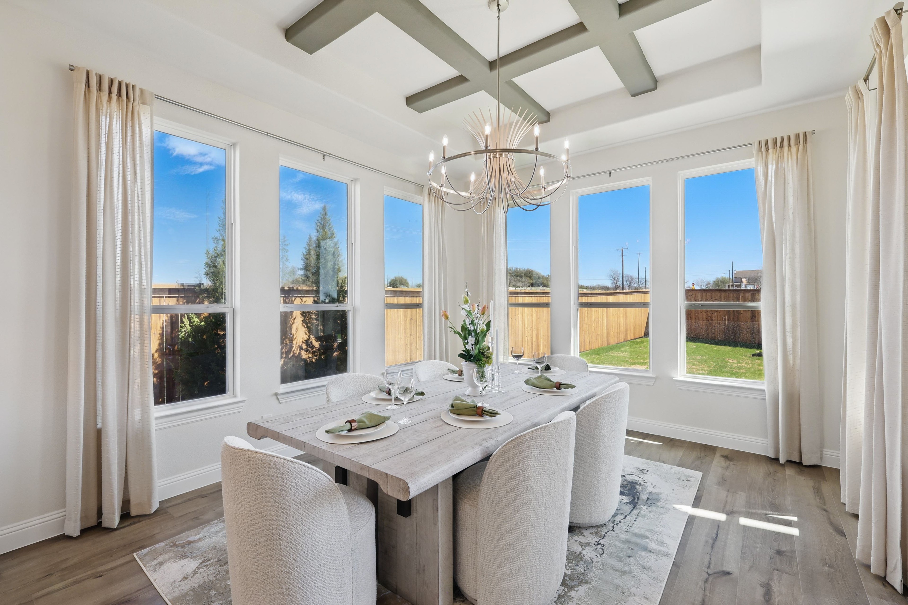 Elegant dining room with chandelier, large windows, and coffered ceiling in Rio Vista at Kelly Ranch.