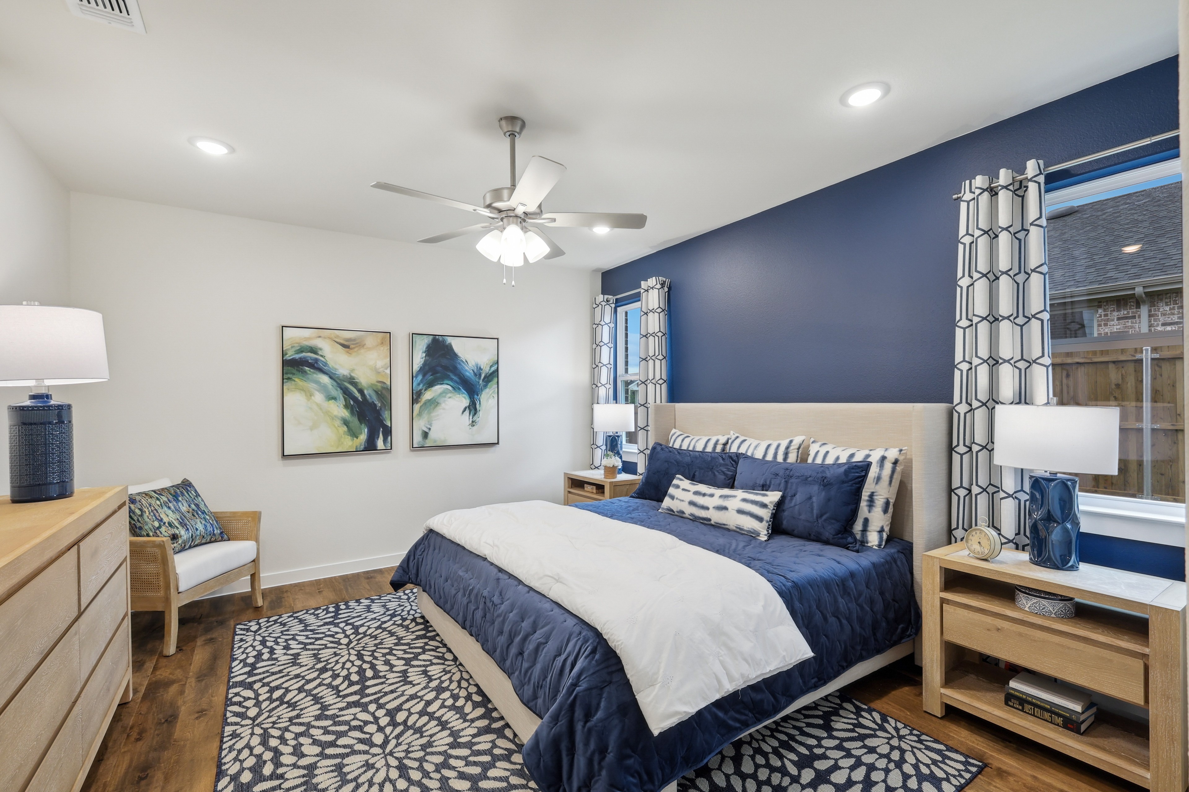 Elegant Churchill bedroom, blue accent wall, modern decor, wooden flooring, cozy ambiance, patterned rug.