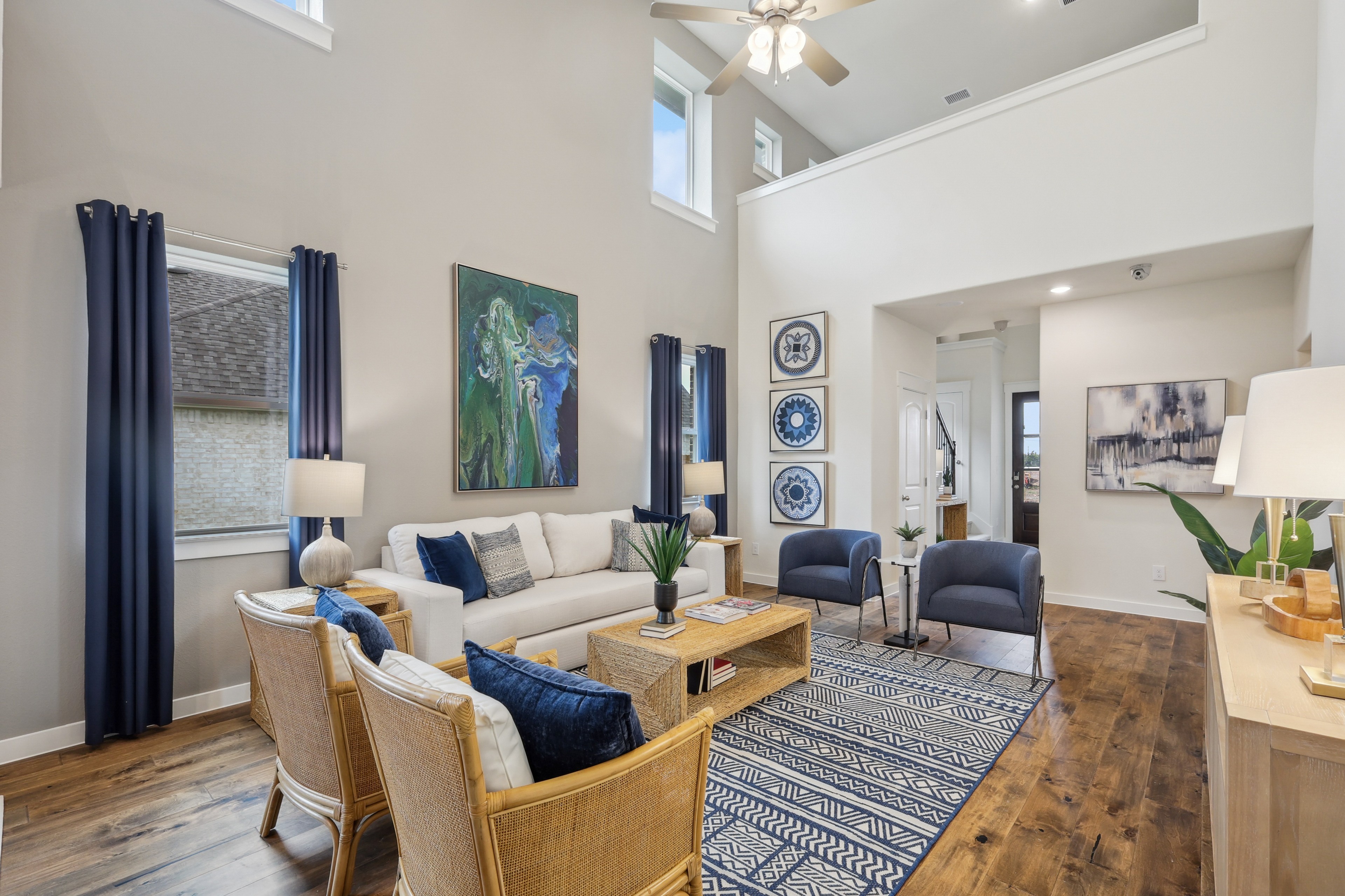 Modern living room, Churchill community, high ceilings, wood flooring, art decor, abundant natural light.