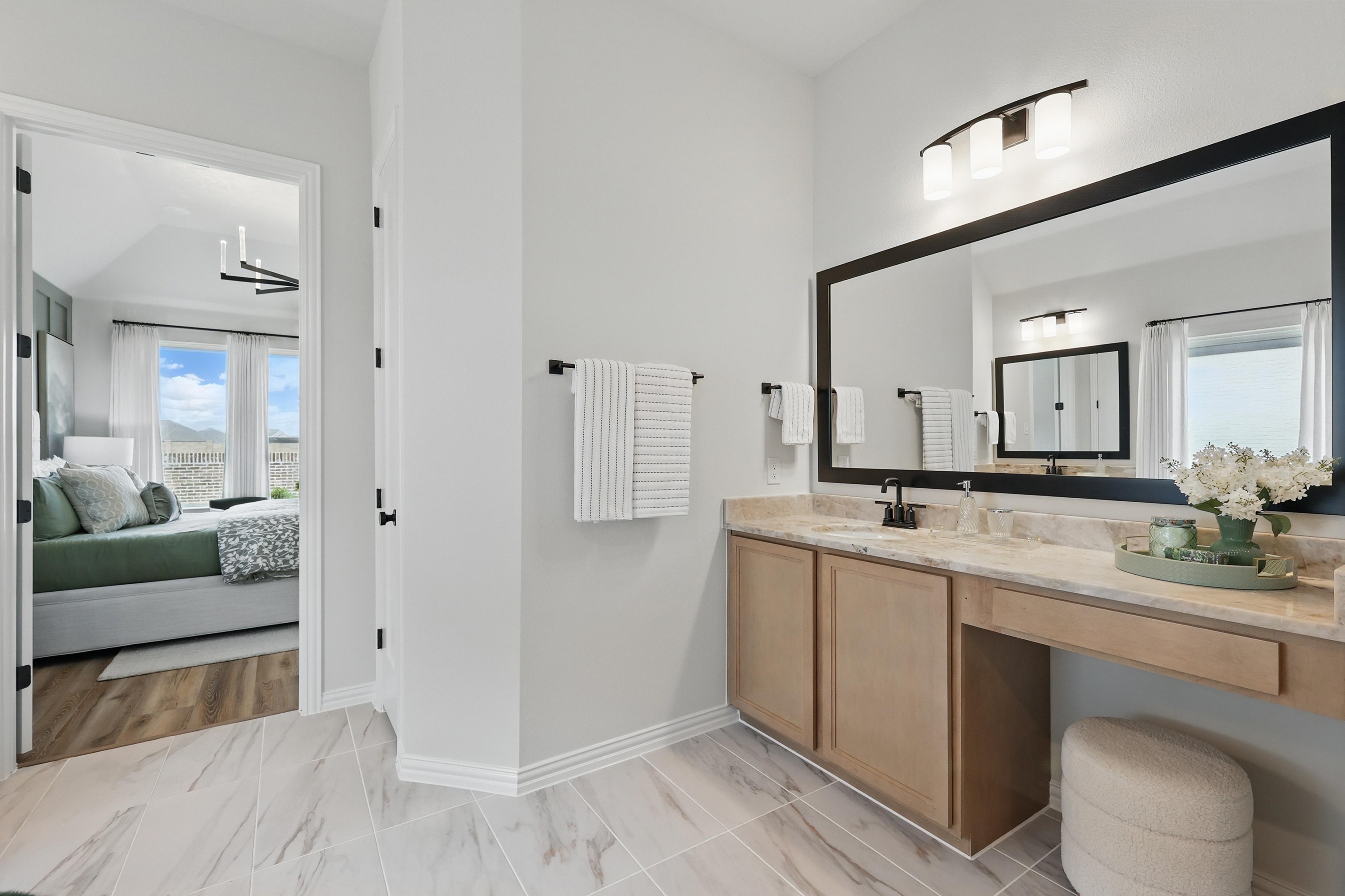 Elegant bathroom vanity with marble countertop, large mirror, and natural light in Westridge community.