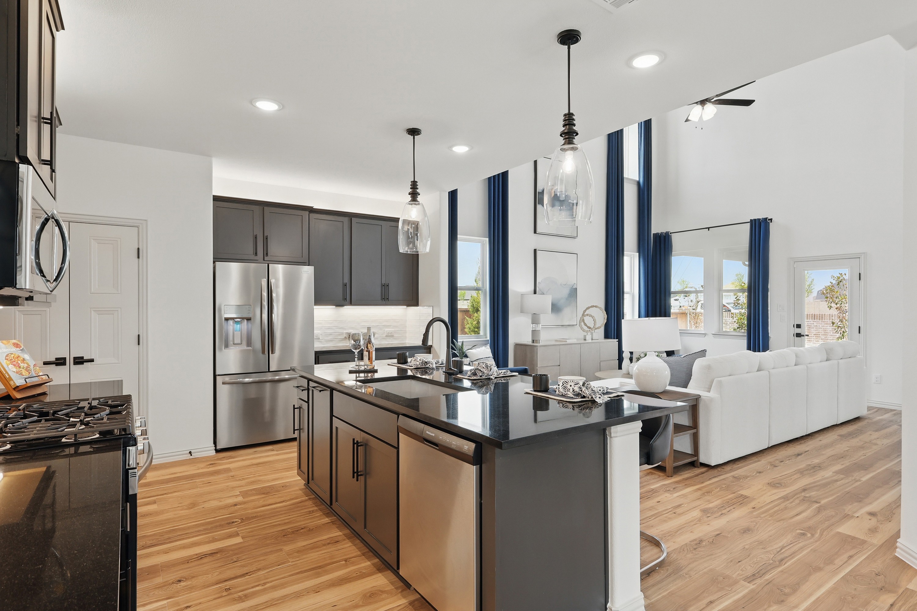 Modern kitchen with black island, stainless-steel appliances, open living area, Westridge community.