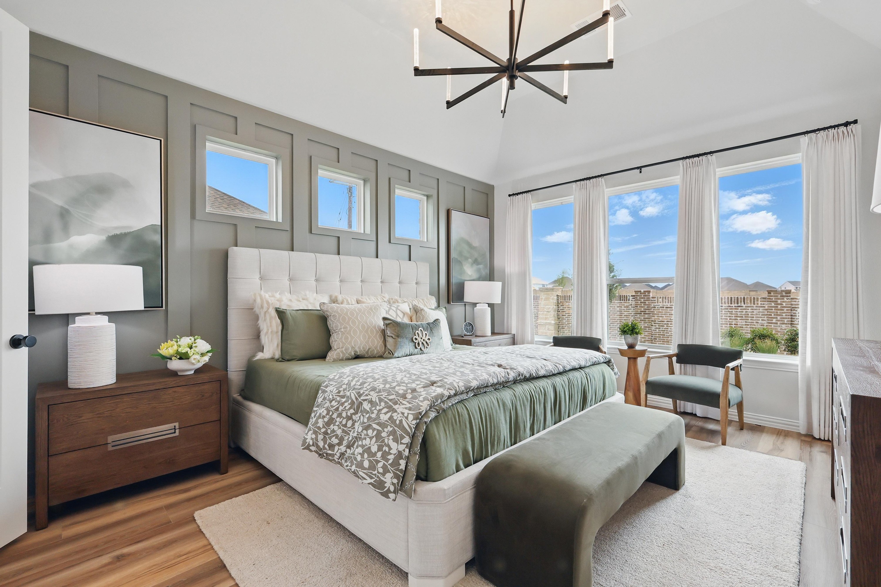 Elegant bedroom with green accents, statement light fixture, and large windows in Westridge community, Texas.