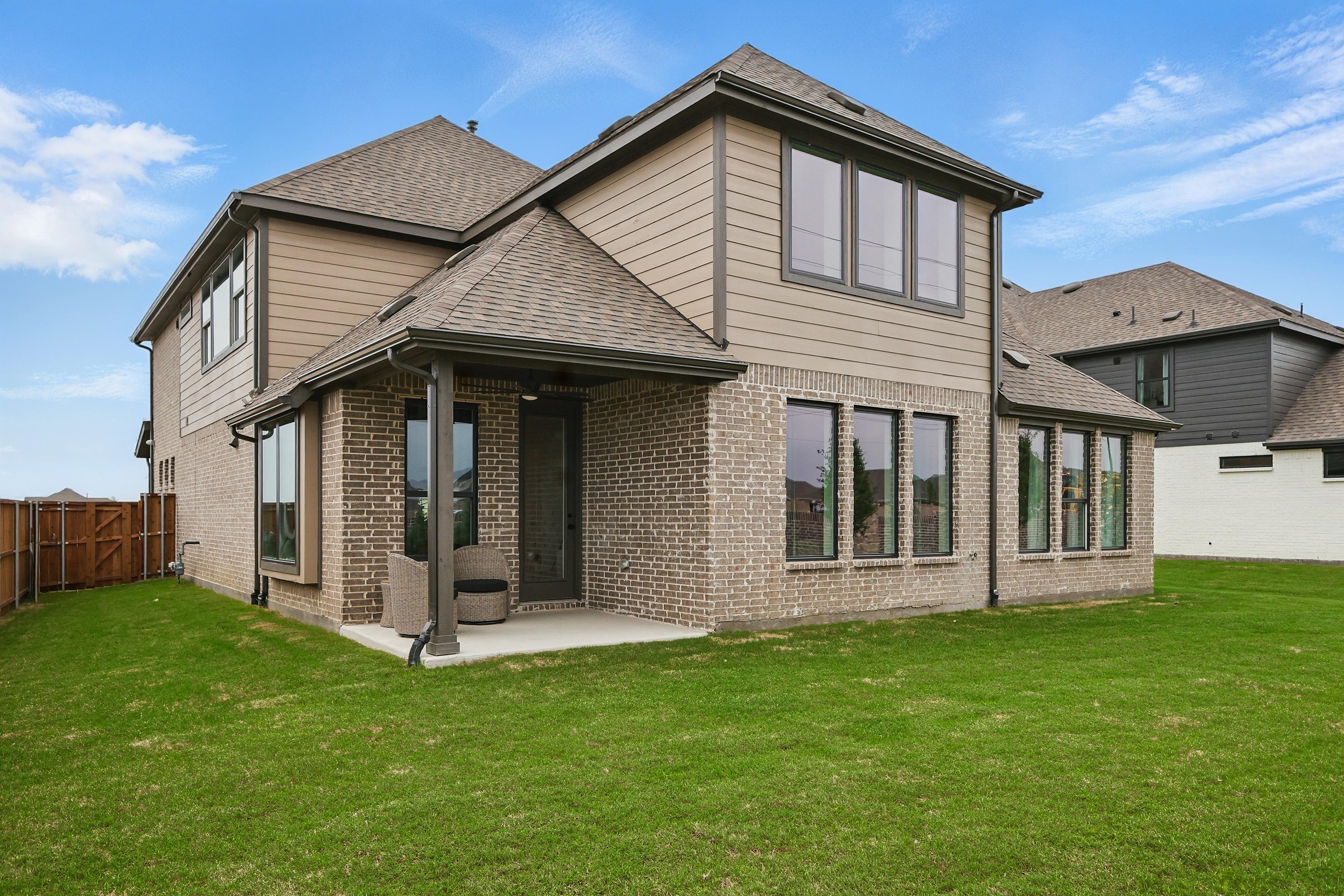 Modern brick two-story home in Westridge community with spacious backyard and large windows.