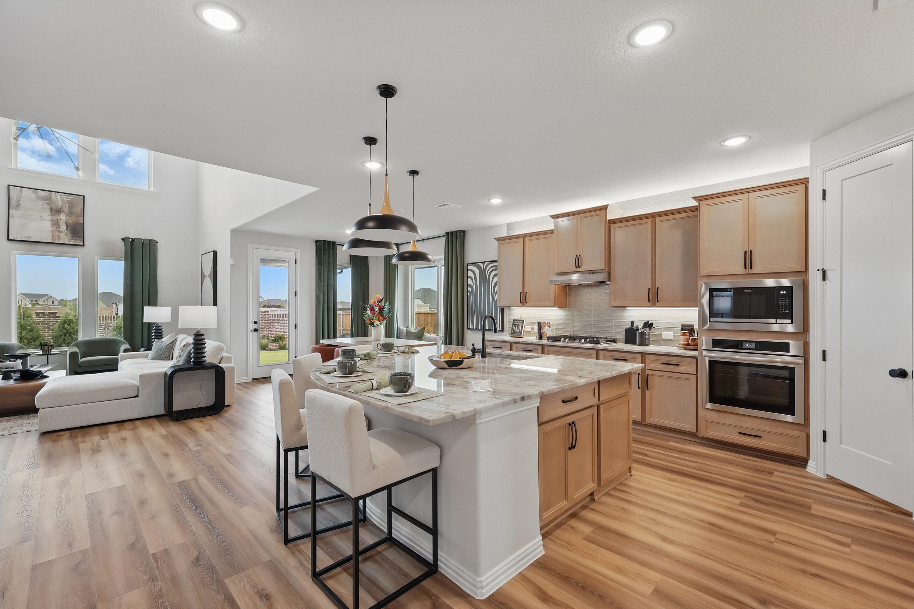Open-plan kitchen and living area with wood cabinets, island, modern lighting, in Westridge community.