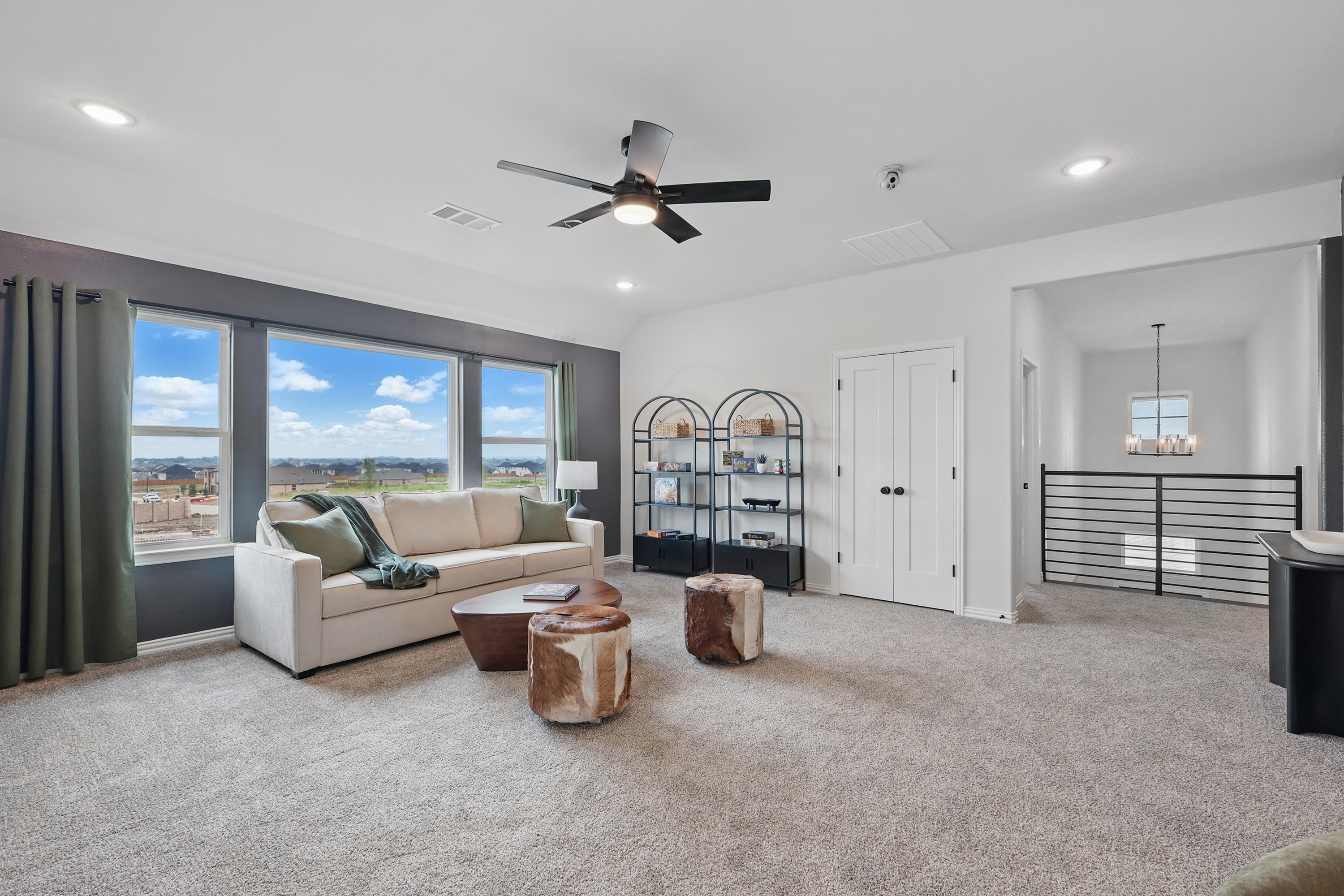 Spacious living room with beige sofa, large windows, modern fan, and views, Westridge community.